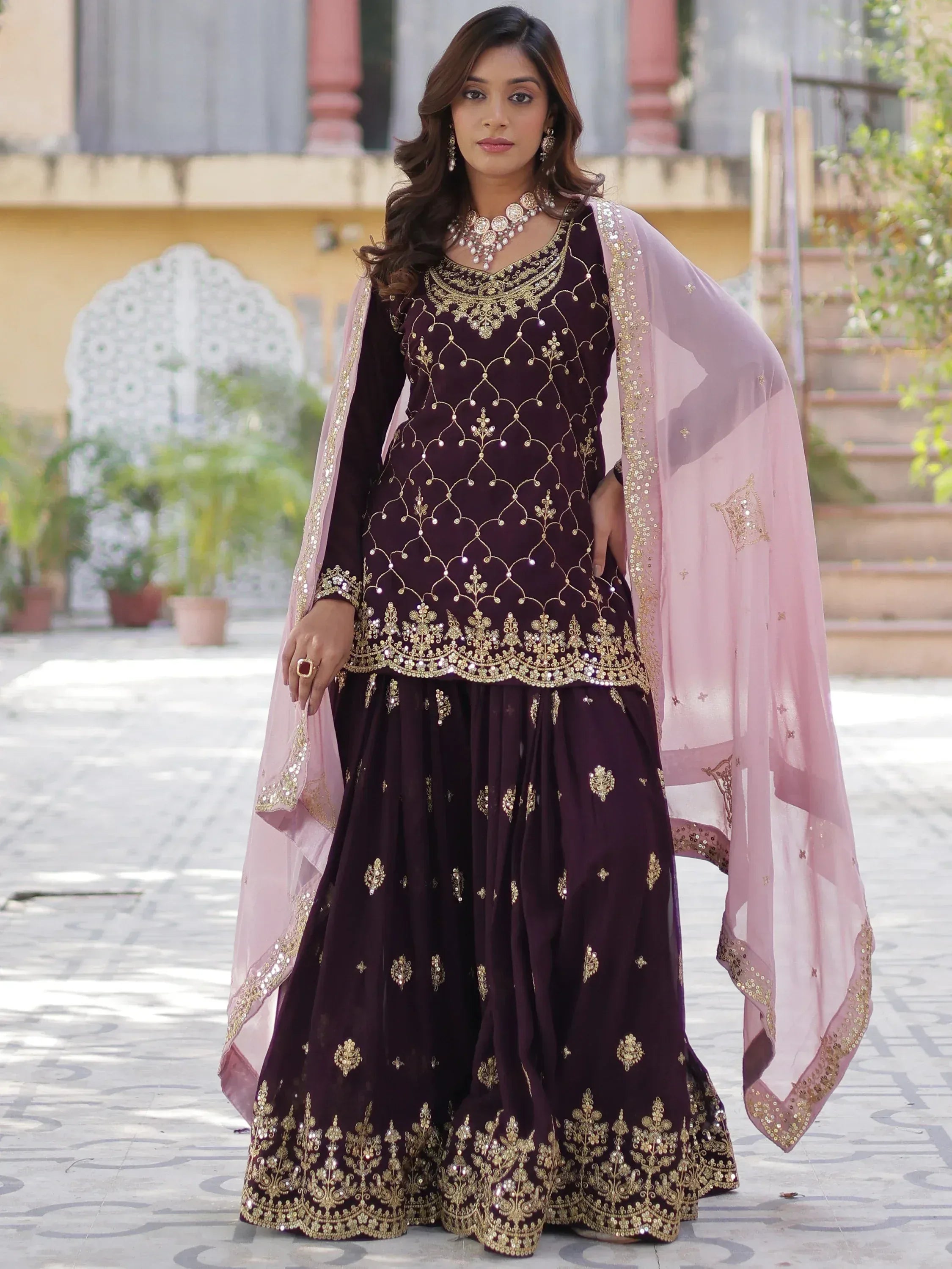Elegant purple Indian ethnic wear with gold embroidery and pink dupatta, perfect for festive occasions.