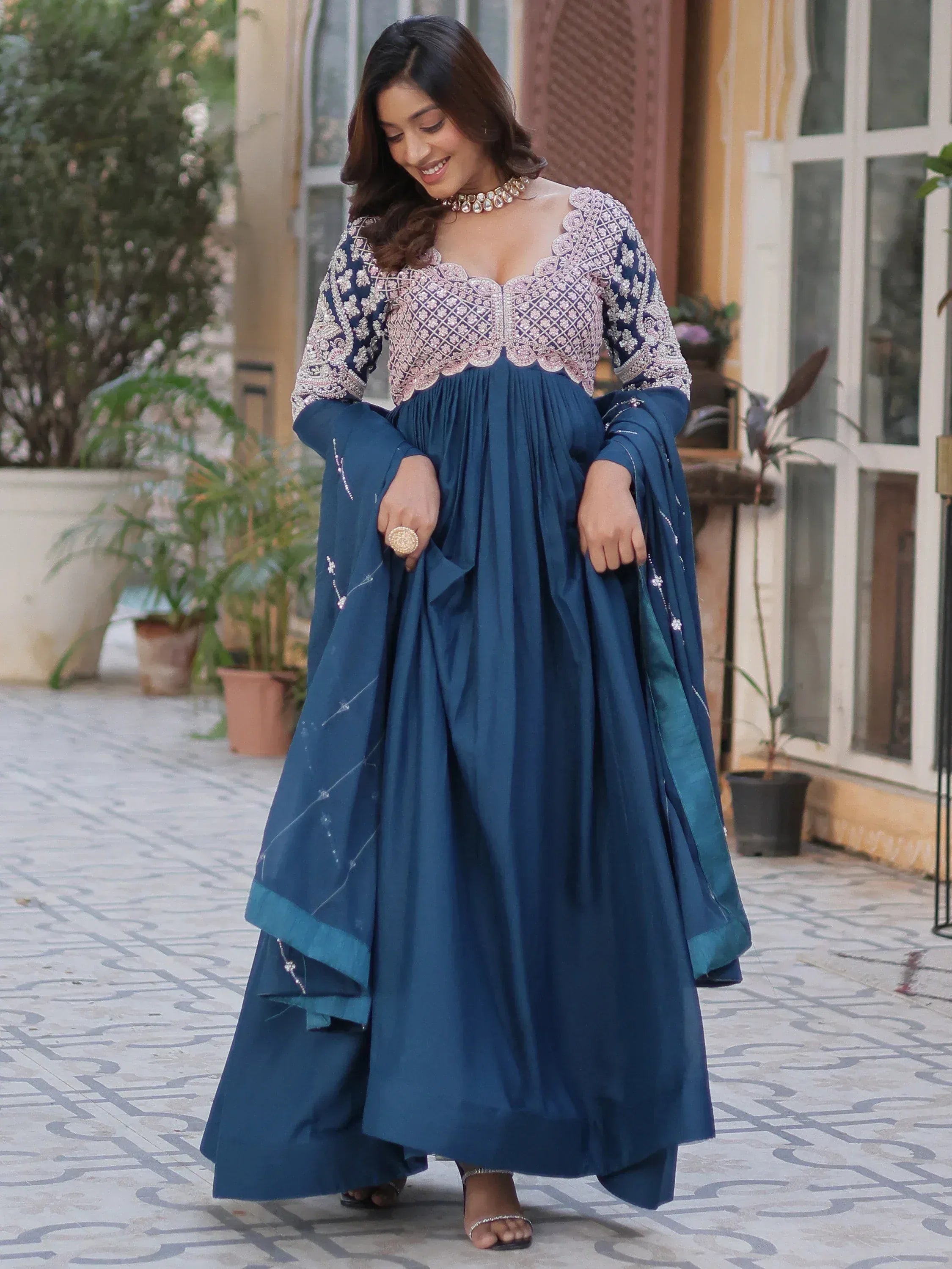 Woman in navy blue embroidered ethnic gown with scalloped neckline, perfect for Indian occasions