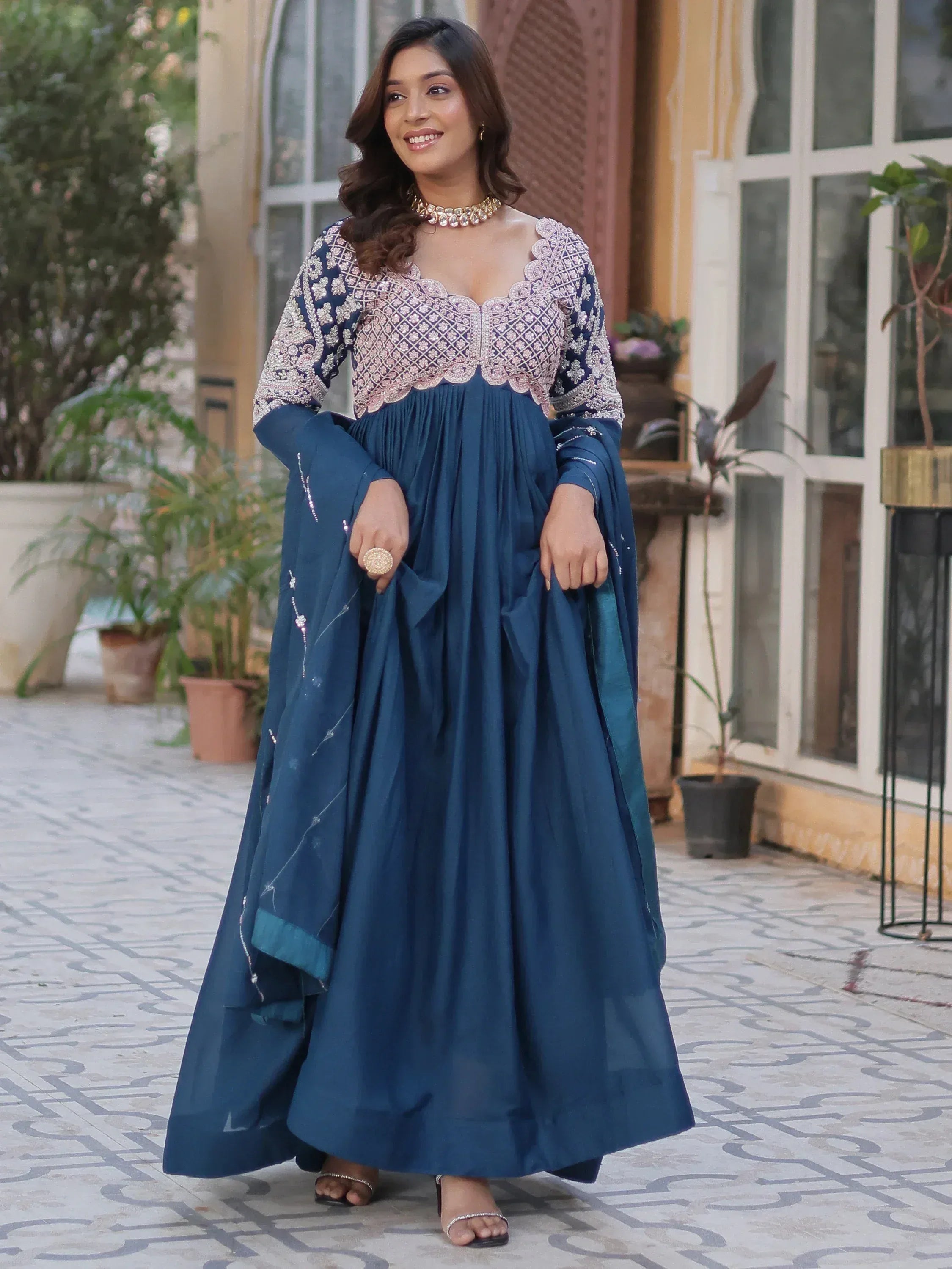 Woman in navy blue embroidered ethnic gown with scalloped neckline, perfect for Indian occasions