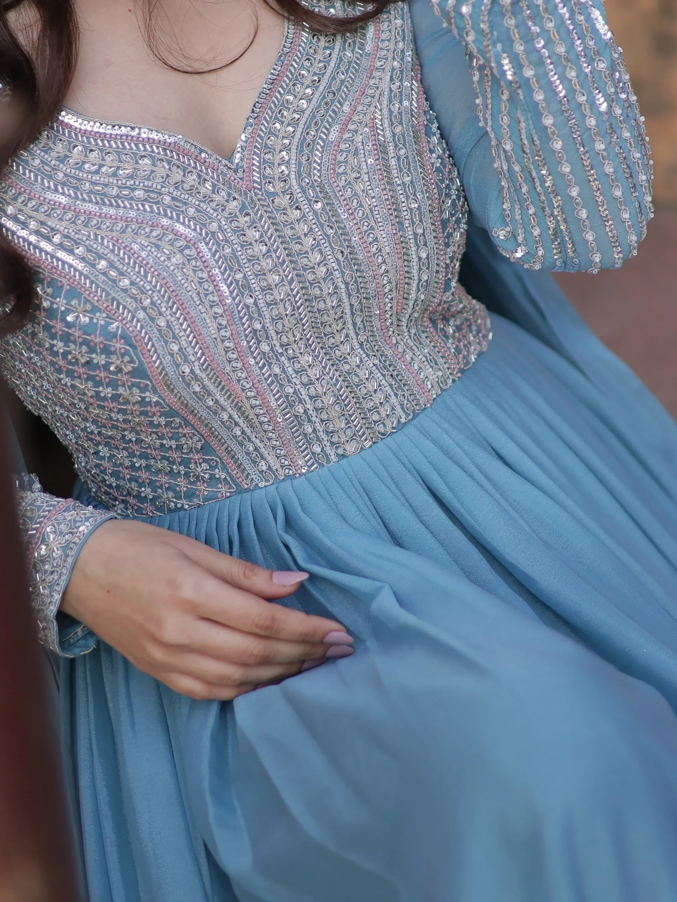 Elegant blue ethnic gown with intricate silver and pink beadwork, perfect for festive occasions.