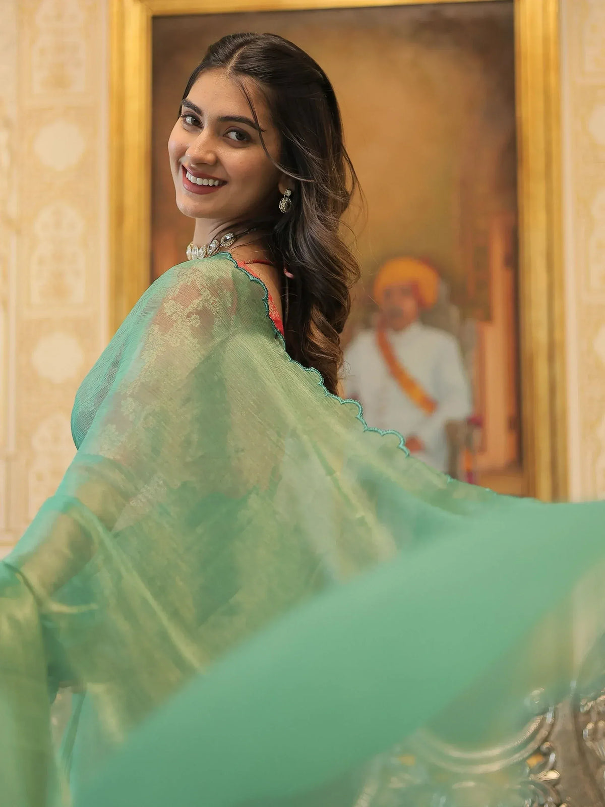 Woman in elegant green sheer saree with scalloped border, traditional Indian ethnic wear