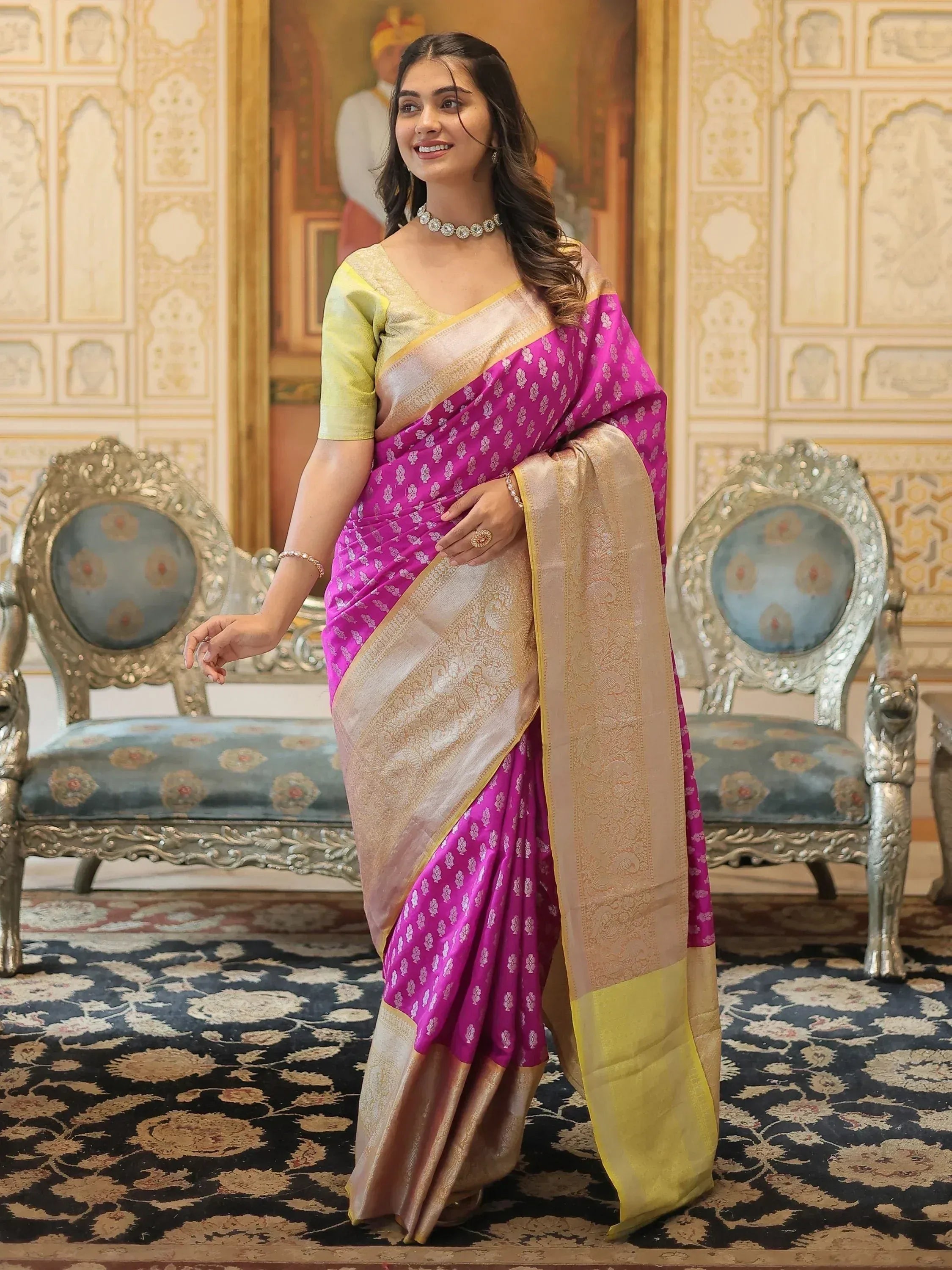 Woman in vibrant pink and gold designer saree with intricate patterns, perfect for Indian ethnic wear occasions.