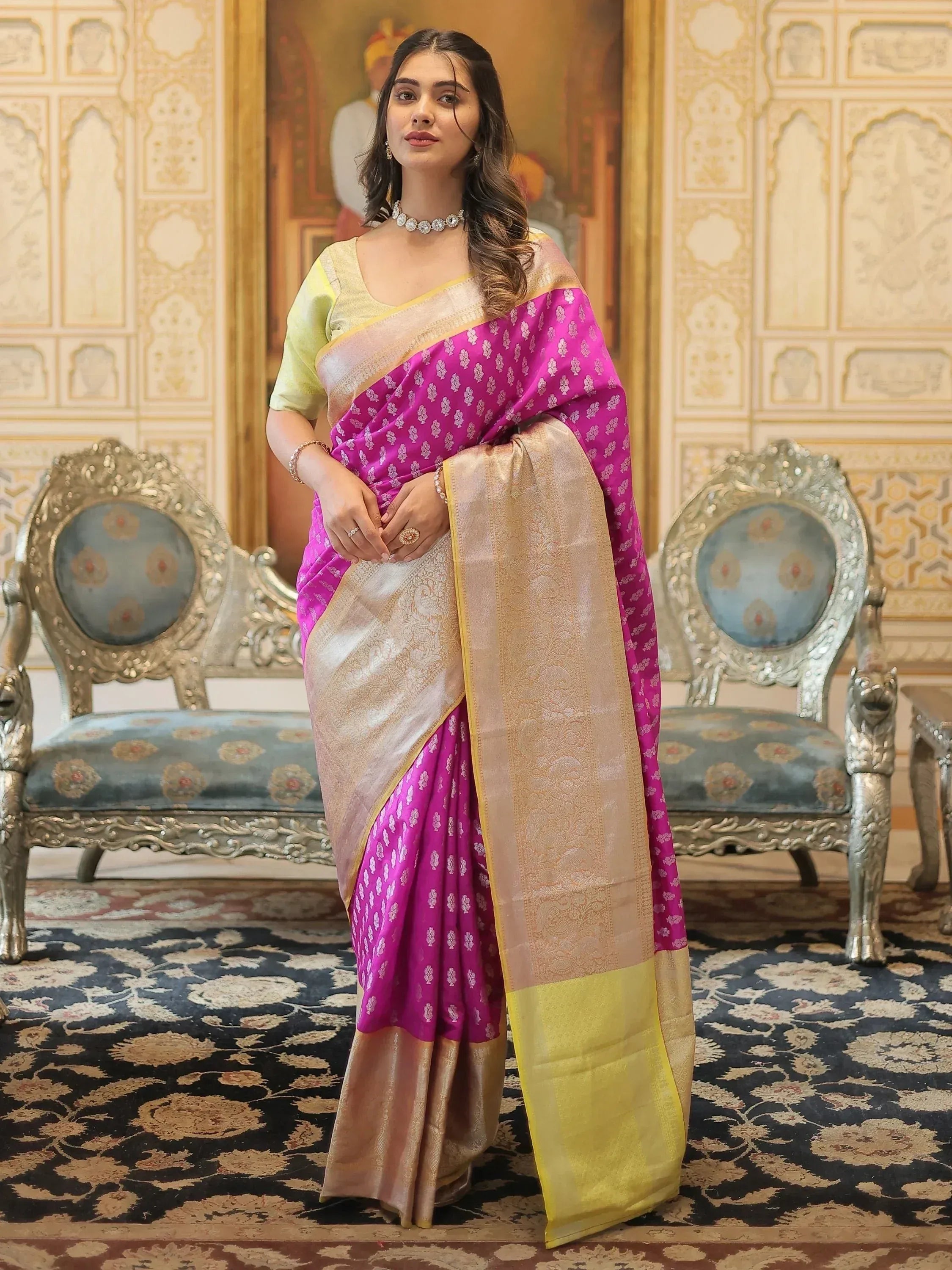 Woman in vibrant pink and gold designer saree with intricate patterns, styled for ethnic occasions