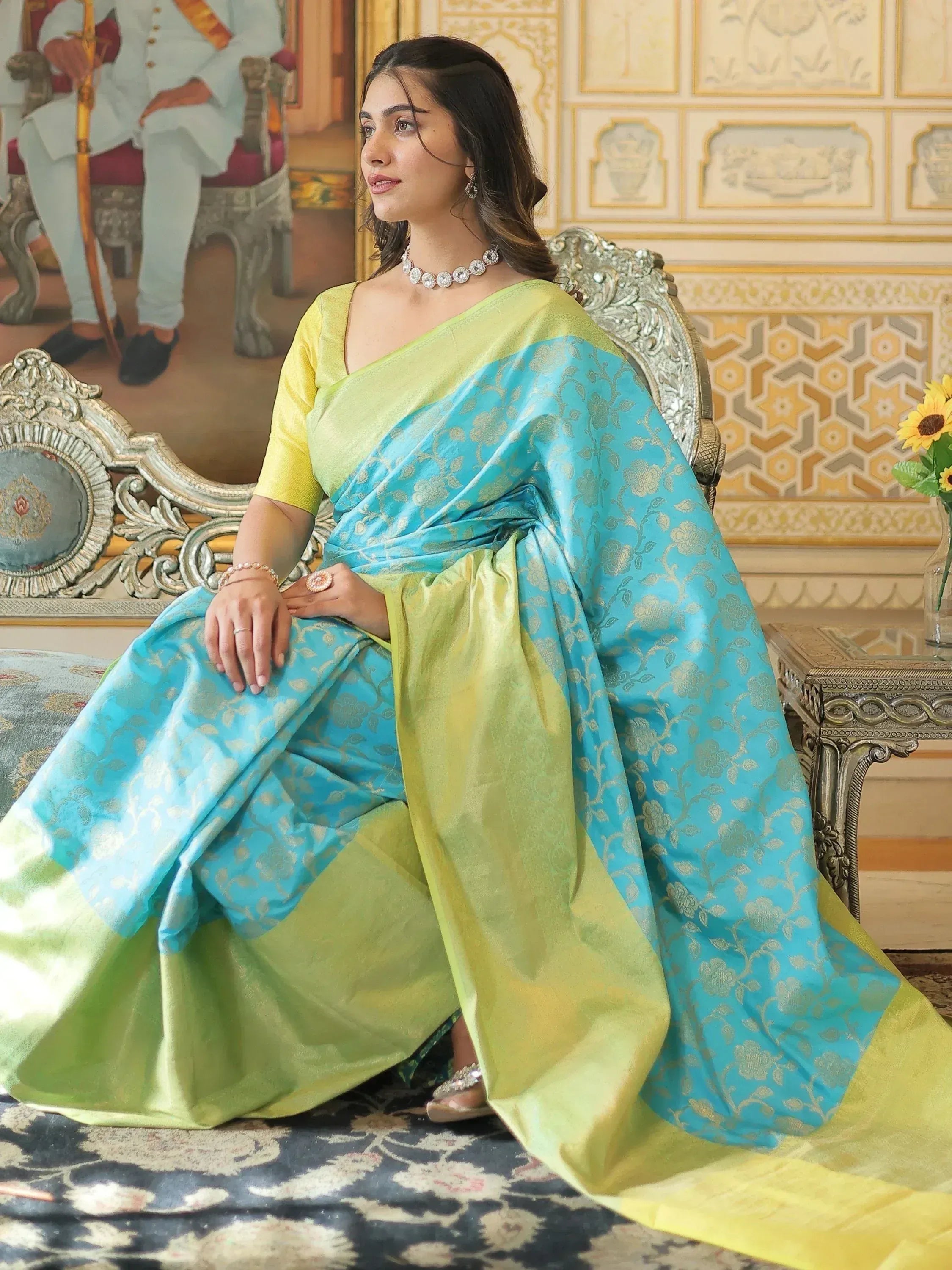 Woman in turquoise and lime green designer saree with gold floral print, elegant ethnic wear