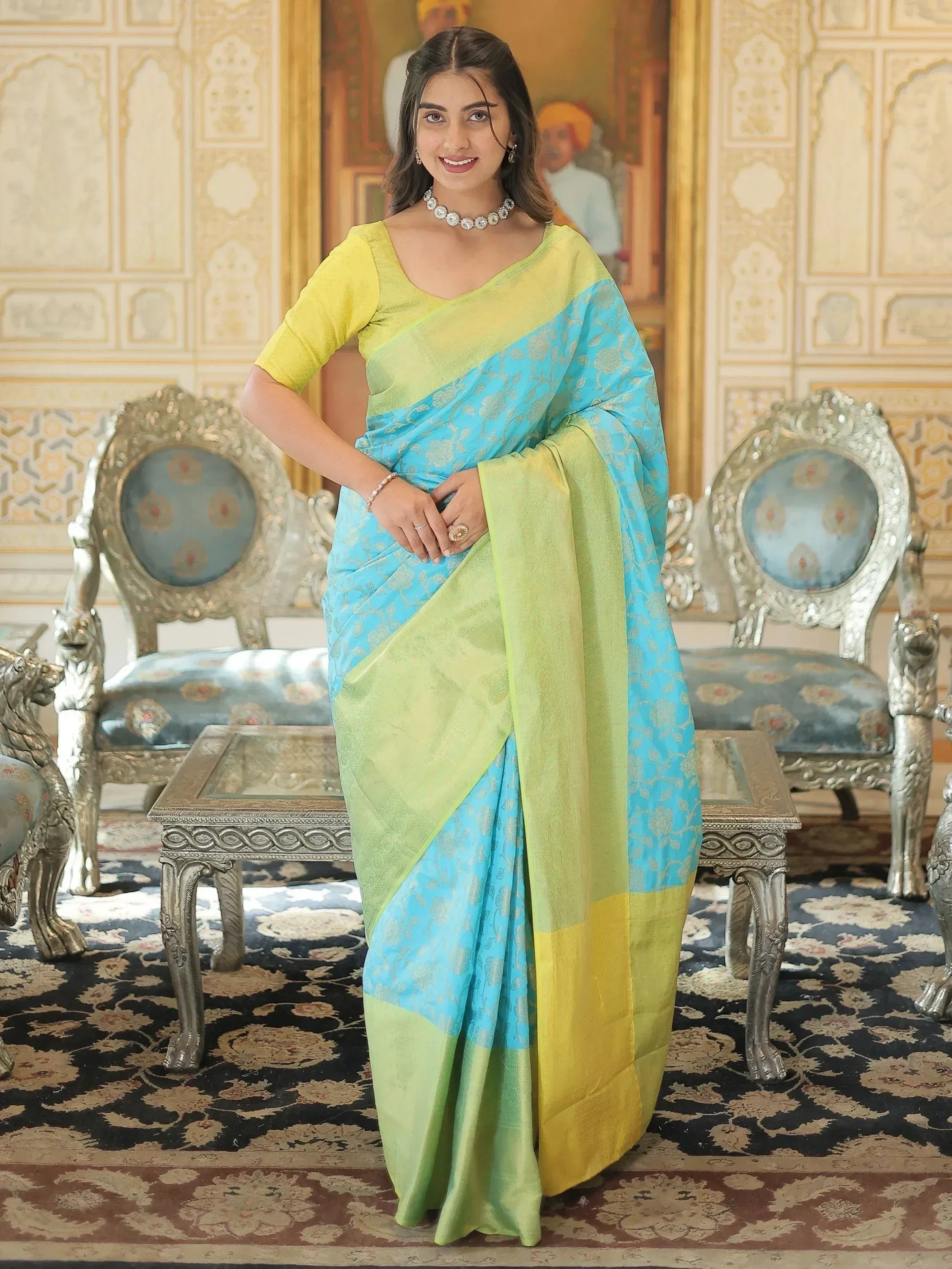 Woman in vibrant blue and lime green designer saree with gold floral patterns, perfect for ethnic occasions.