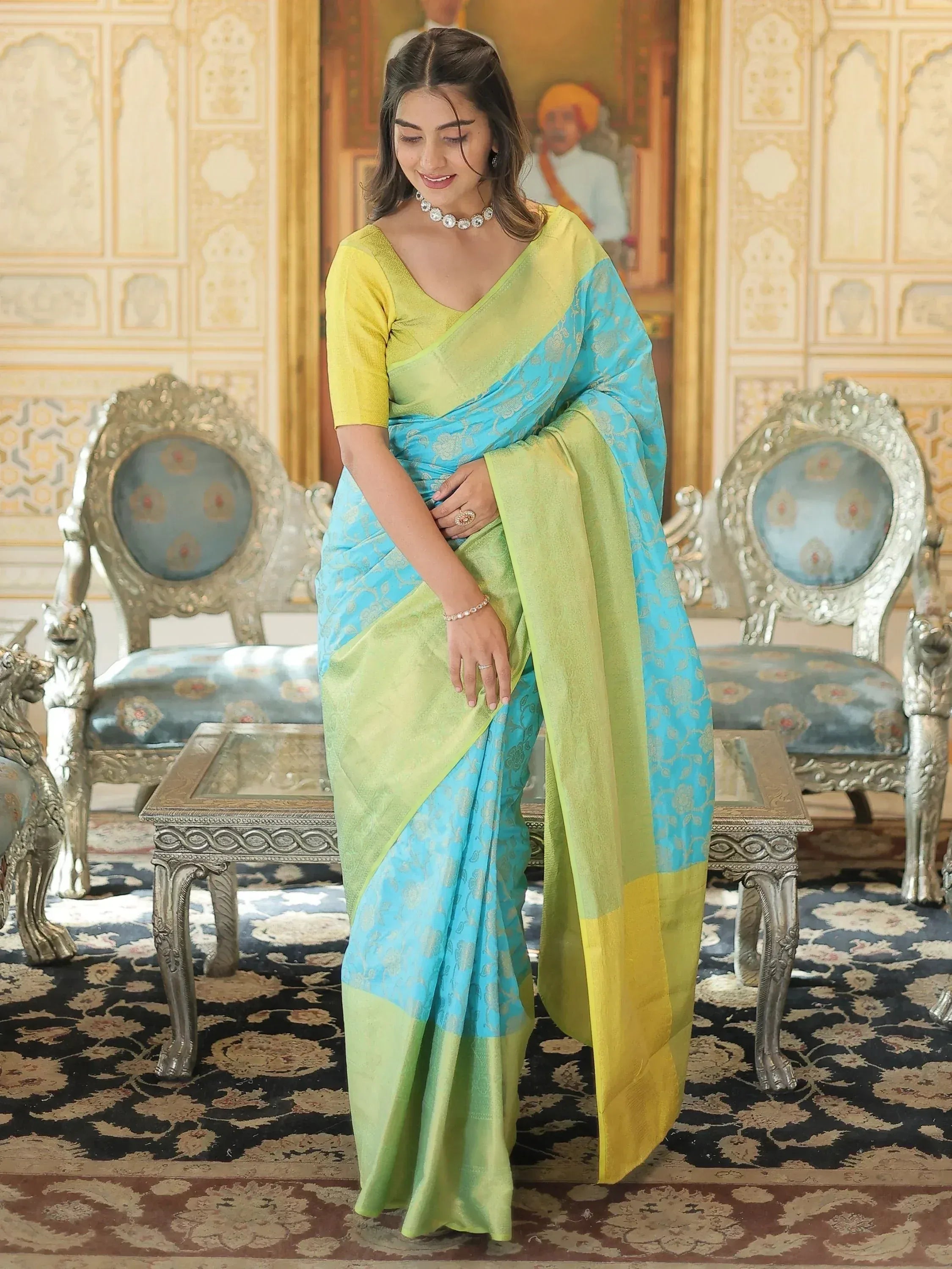 Woman in elegant blue and green designer saree with gold motifs, perfect for Indian ethnic wear occasions