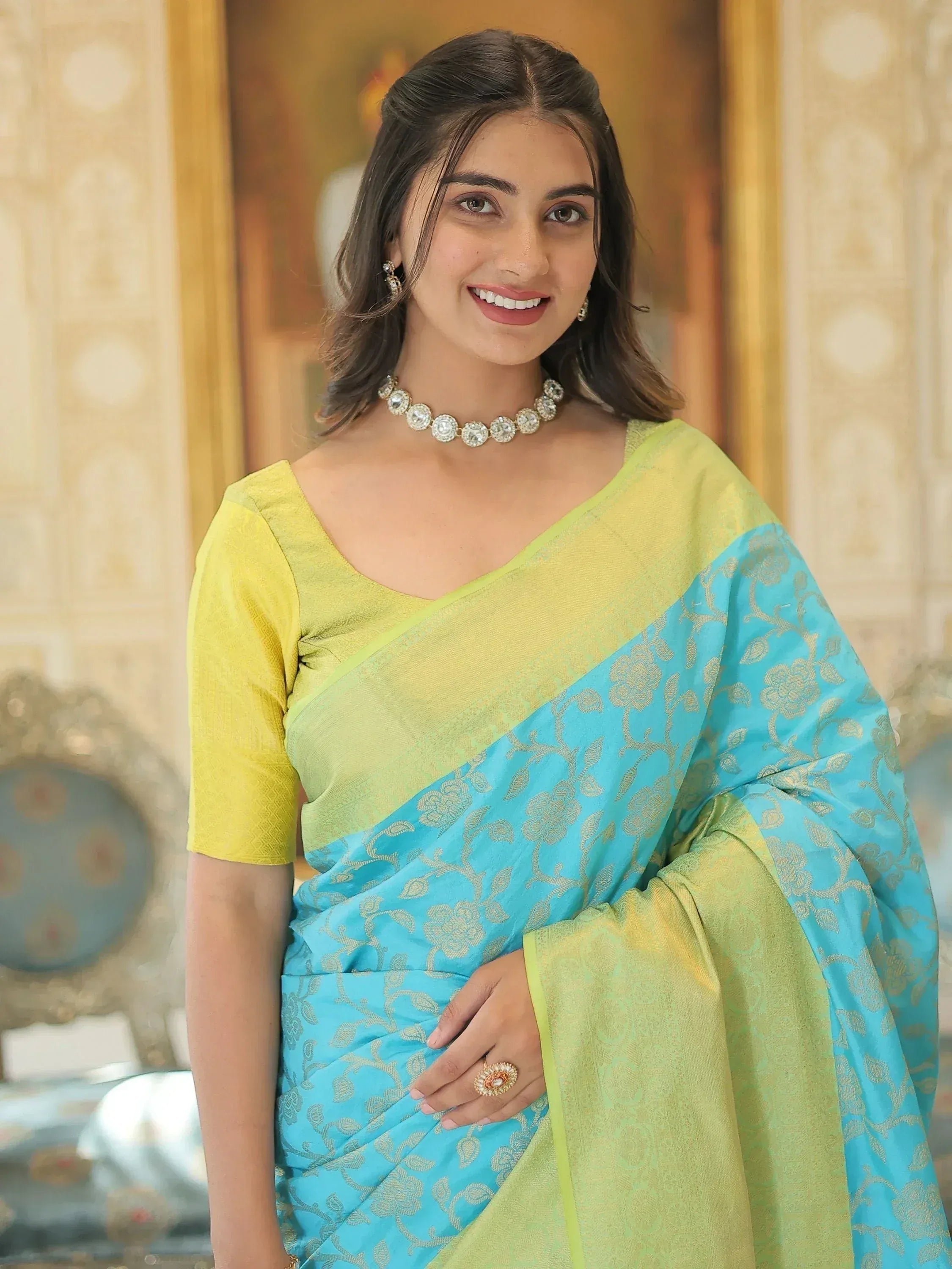 Woman in vibrant blue and lime green designer saree with gold floral motifs, perfect for Indian ethnic occasions