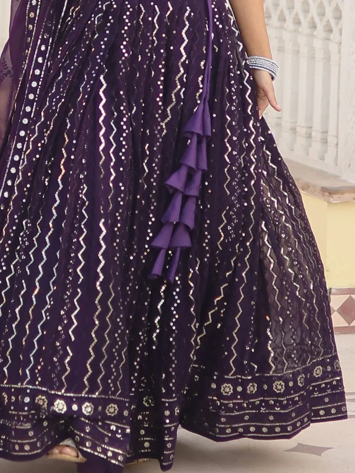 Purple ethnic lehenga with silver zigzag embroidery and ruffle detailing, perfect for festive occasions.