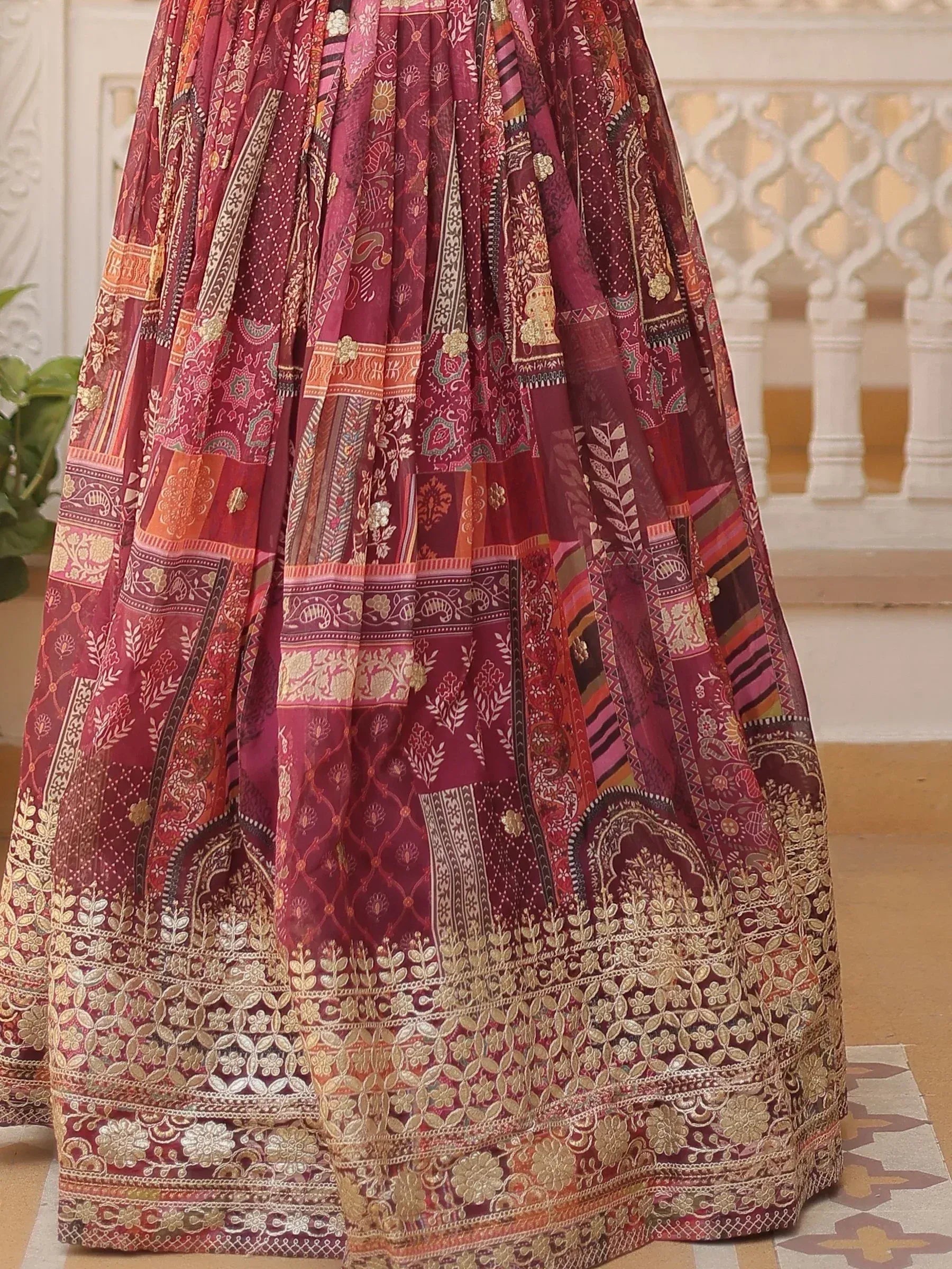 Maroon ethnic lehenga with intricate gold embroidery and patchwork design, perfect for Indian weddings and festivals