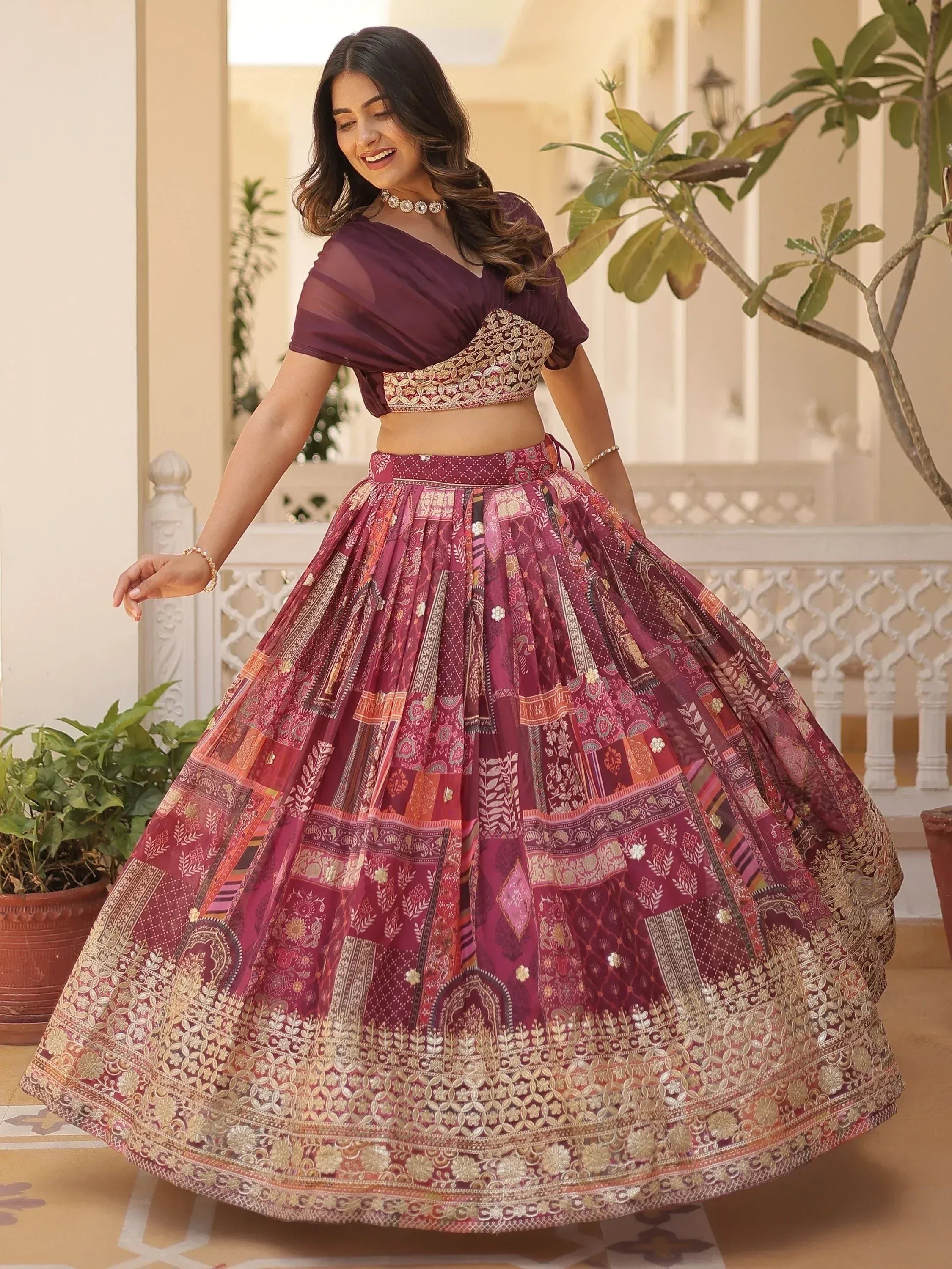 Elegant maroon lehenga choli with intricate gold embroidery and patchwork design, perfect for Indian ethnic occasions.