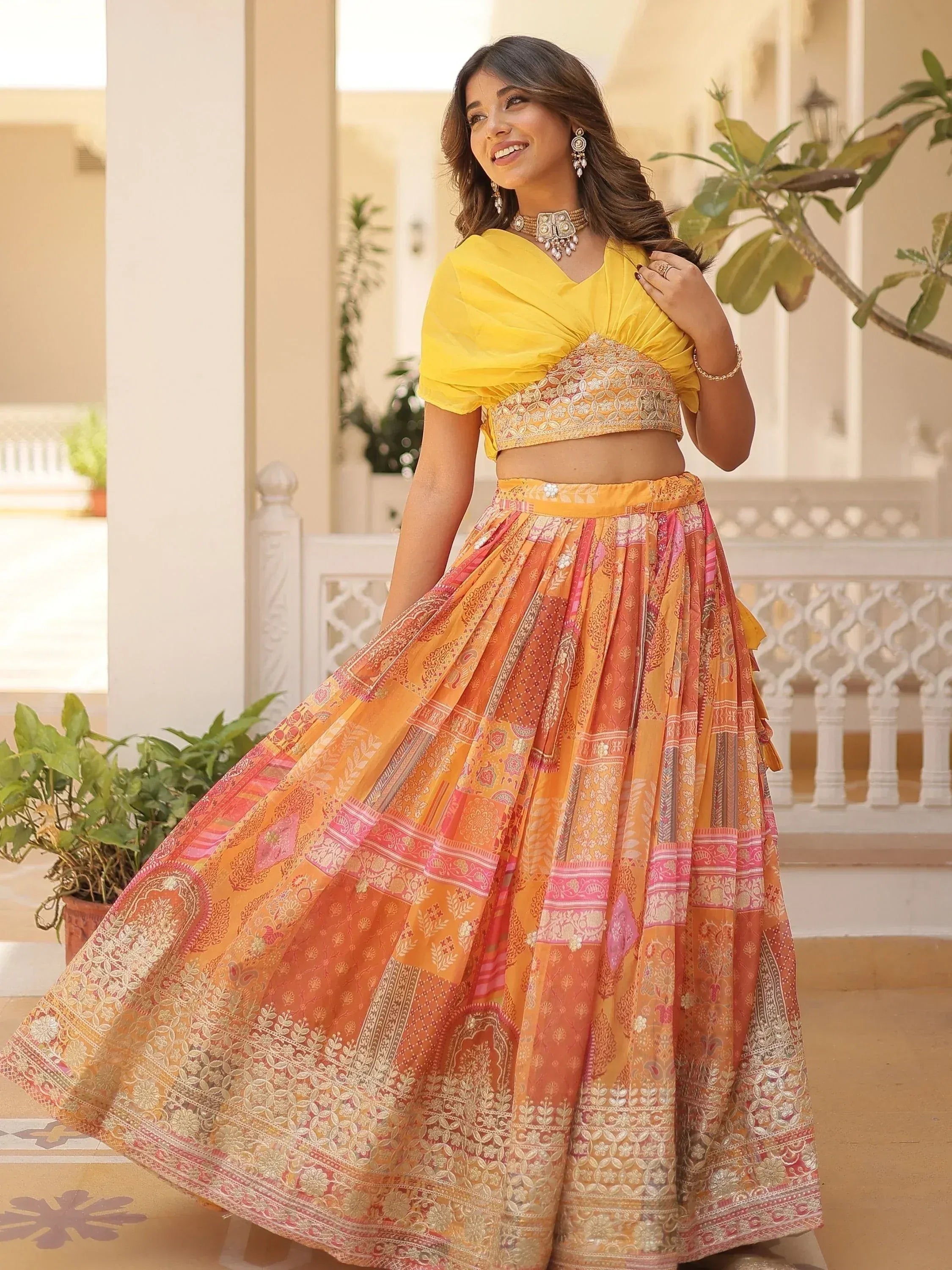 Woman in vibrant yellow and orange printed lehenga choli, perfect for Indian ethnic wear occasions