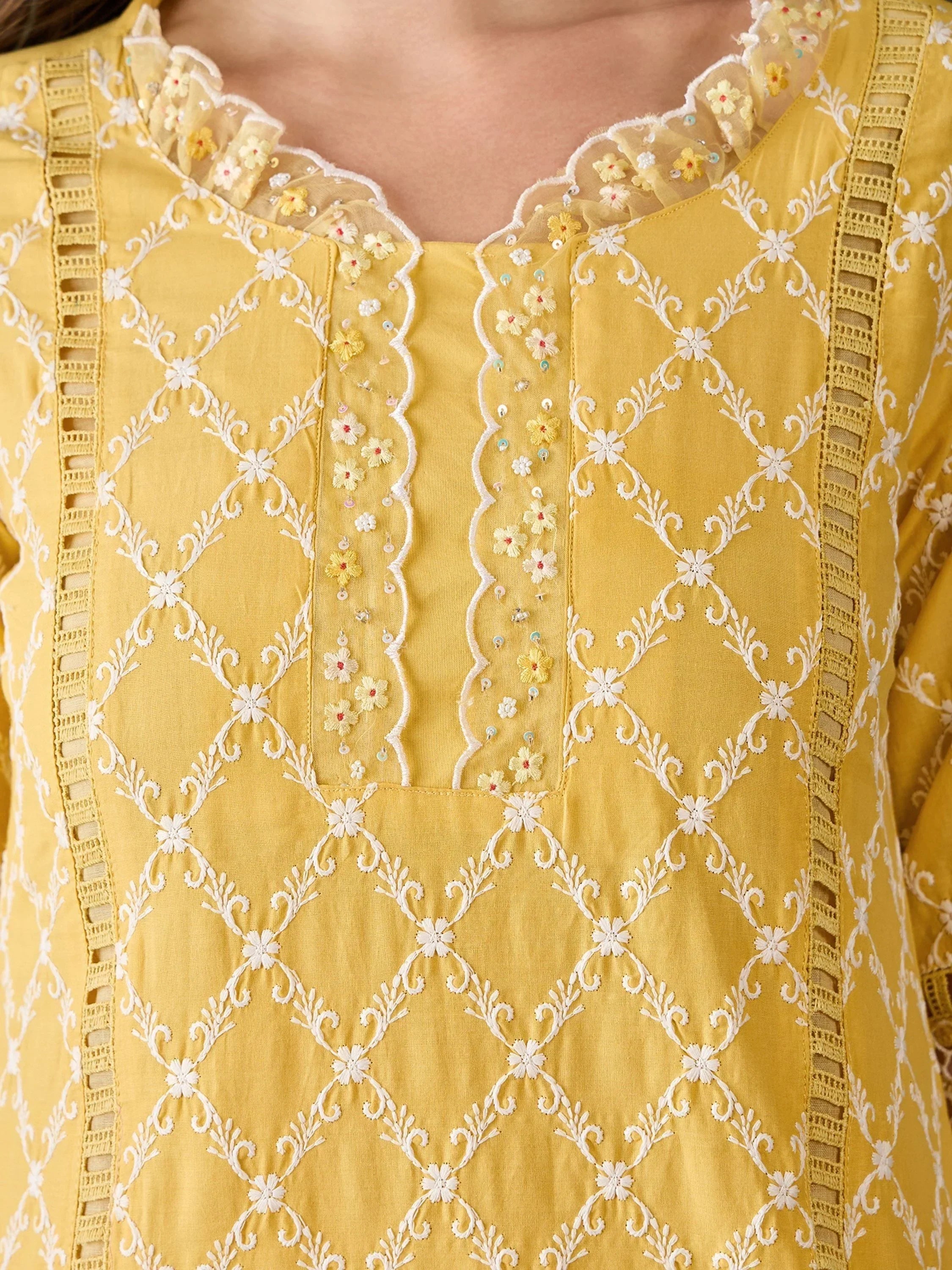 Yellow ethnic kurta with white floral embroidery and lace detailing on neckline