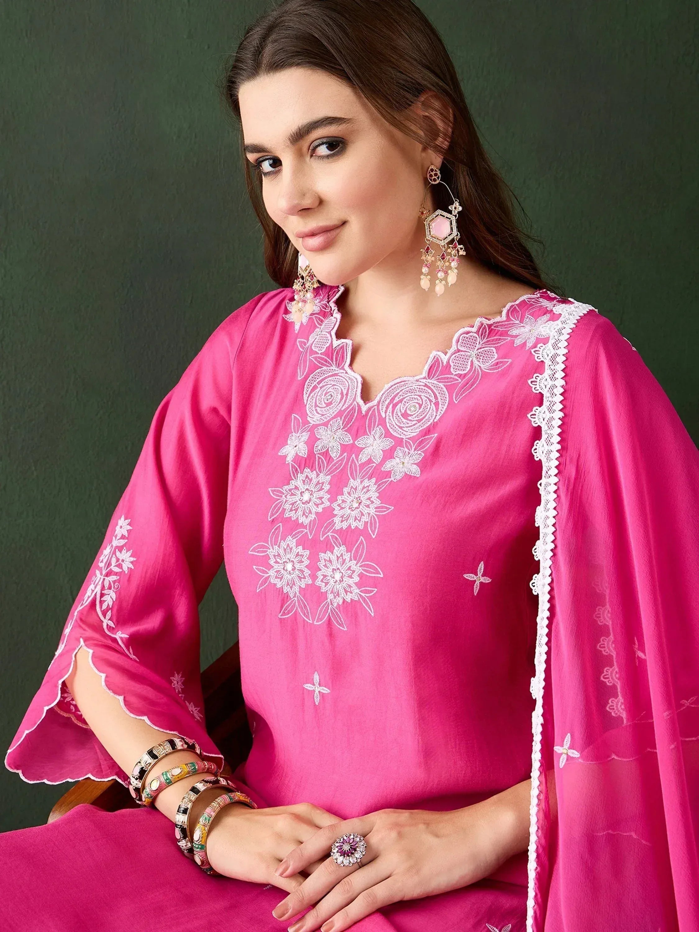 Pink embroidered ethnic kurta with white floral lace detailing, paired with statement earrings and bangles