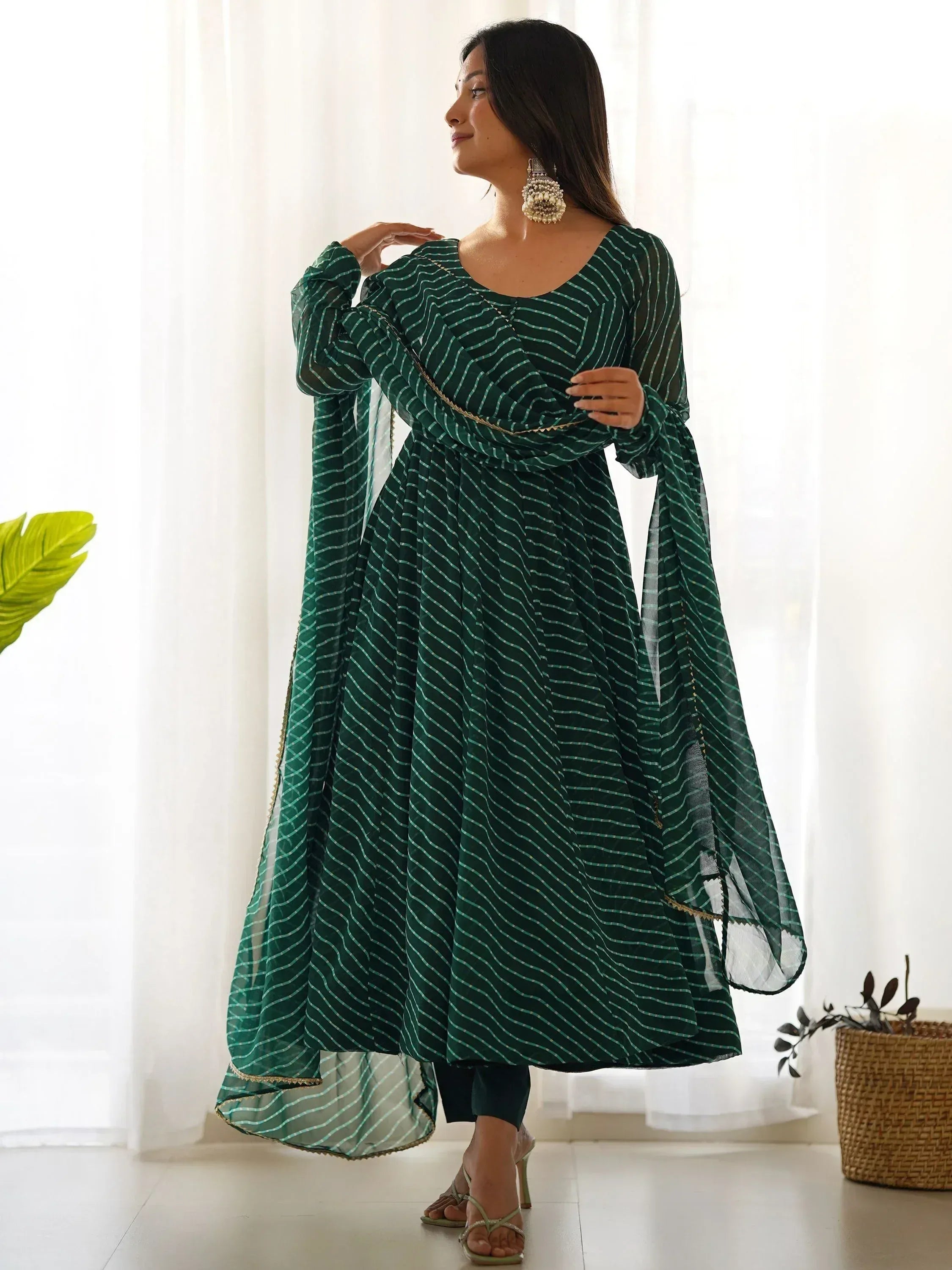 Green striped ethnic anarkali gown with sheer sleeves and gold trim, perfect for Indian occasions.