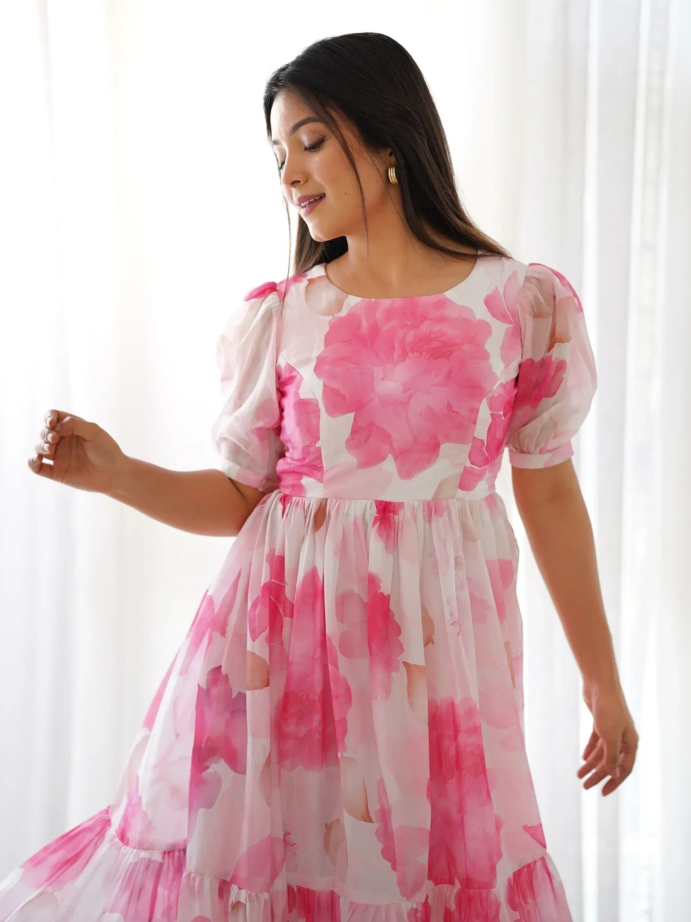 Woman in pink floral print ethnic gown with puff sleeves, perfect for Indian occasions