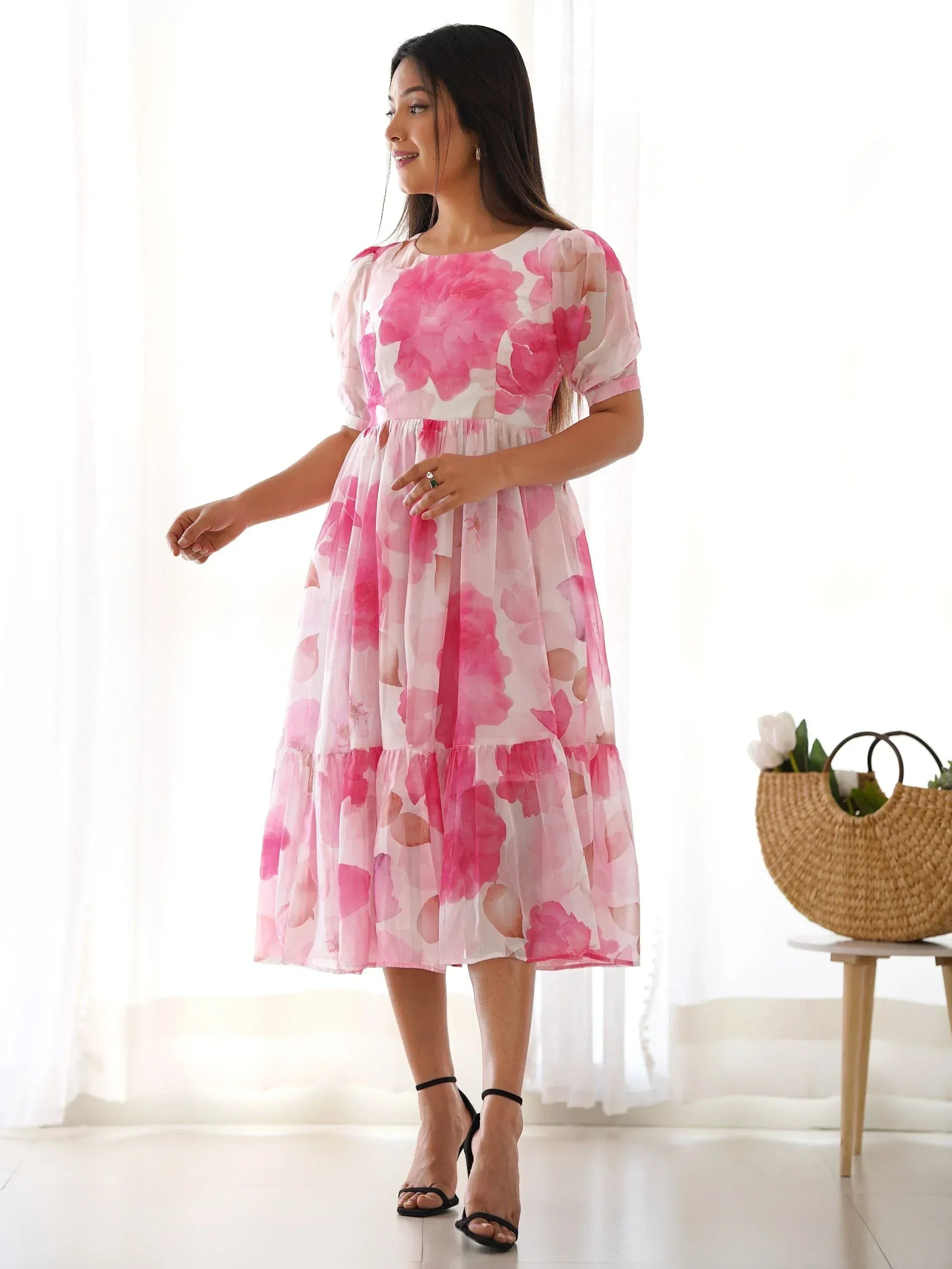 Woman in pink floral print ethnic gown with puff sleeves, tiered skirt, perfect for Indian occasions