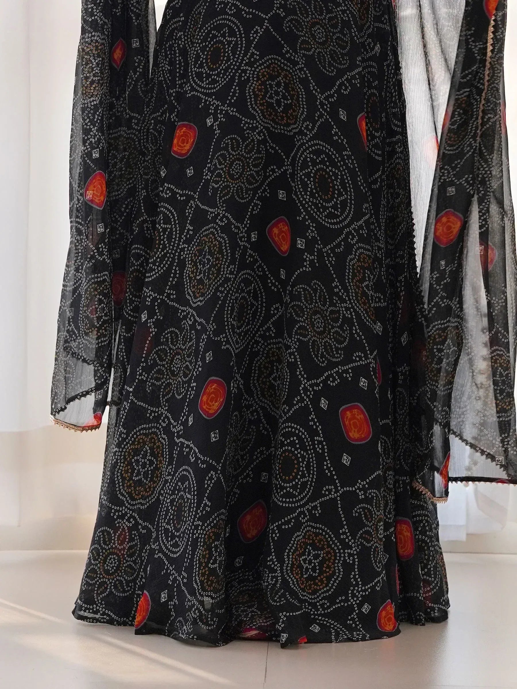 Black ethnic gown with red floral print and sheer sleeves, perfect for Indian occasions