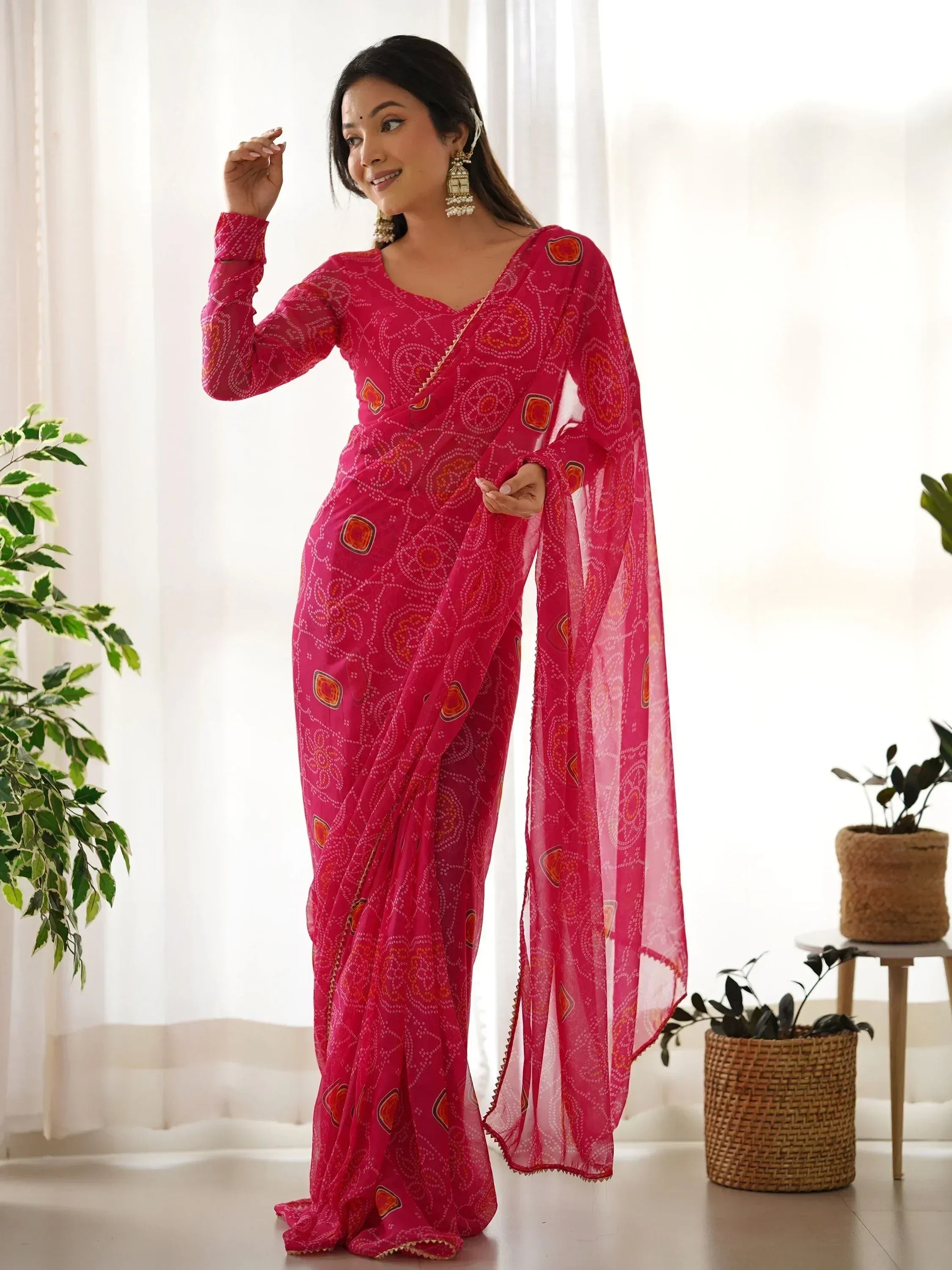 Pink printed saree with ethnic motifs, stylish drape, and gold trim for Indian festive wear