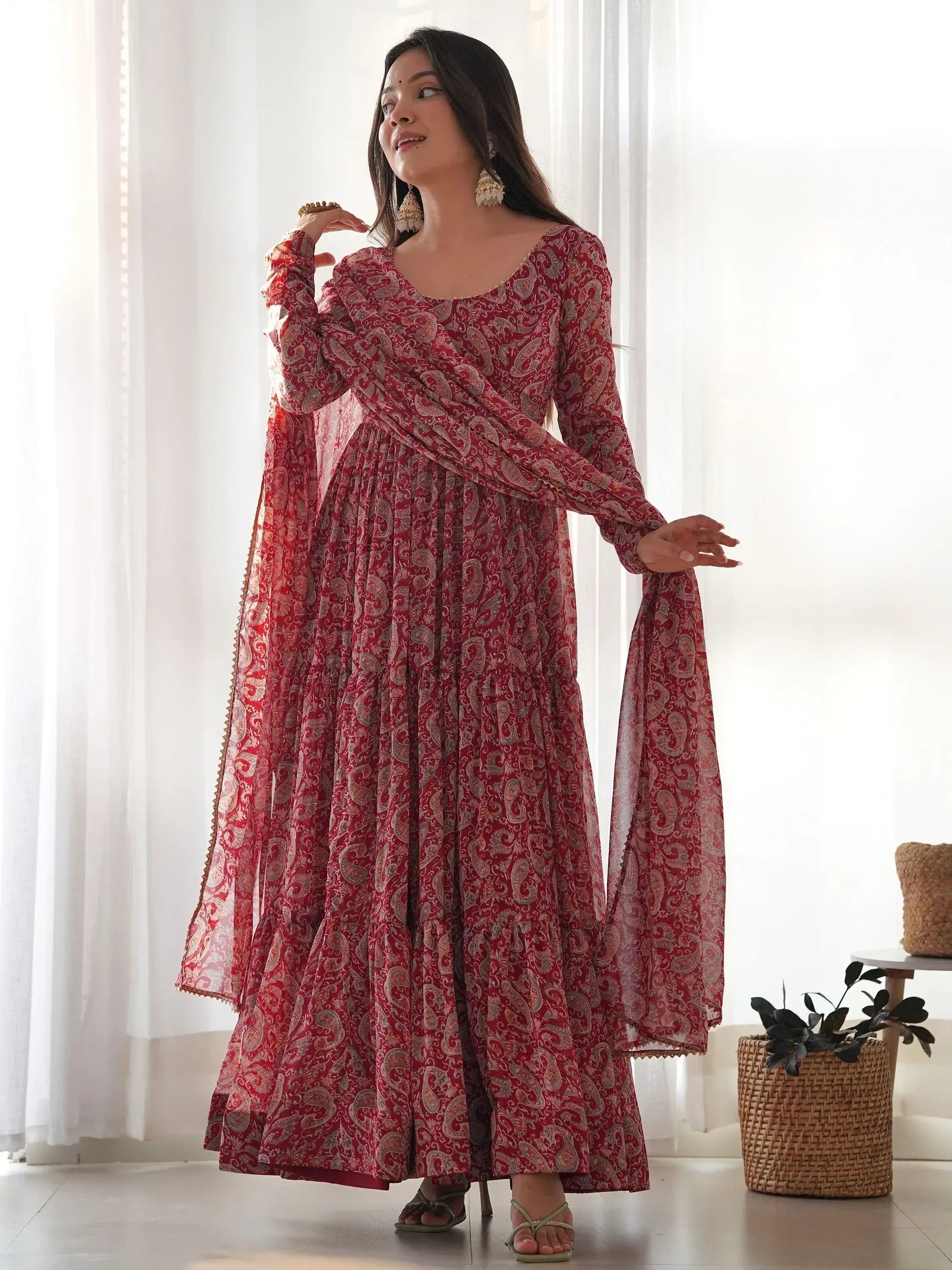 Red paisley print ethnic gown with flared sleeves and layered skirt, perfect for Indian occasions