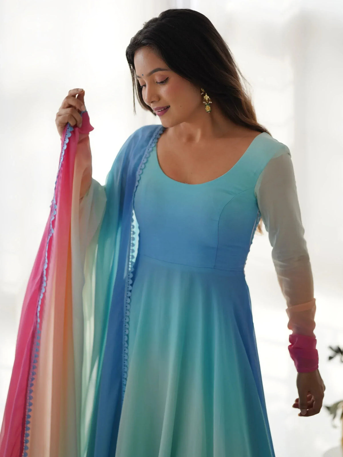 Woman in blue ombre ethnic gown with sheer sleeves and pink dupatta, perfect for Indian occasions