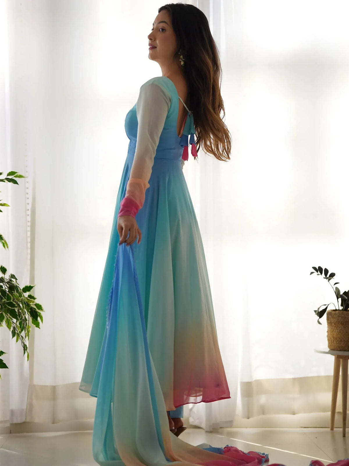 Woman in blue ombre ethnic gown with sheer sleeves and tassel back, perfect for Indian festive wear