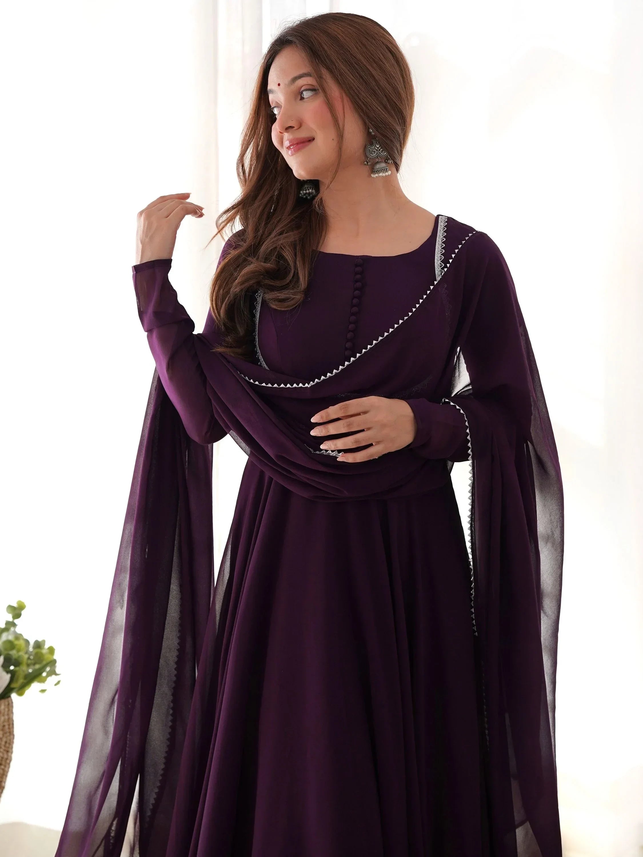 Woman in deep purple ethnic gown with dupatta and silver jhumka earrings