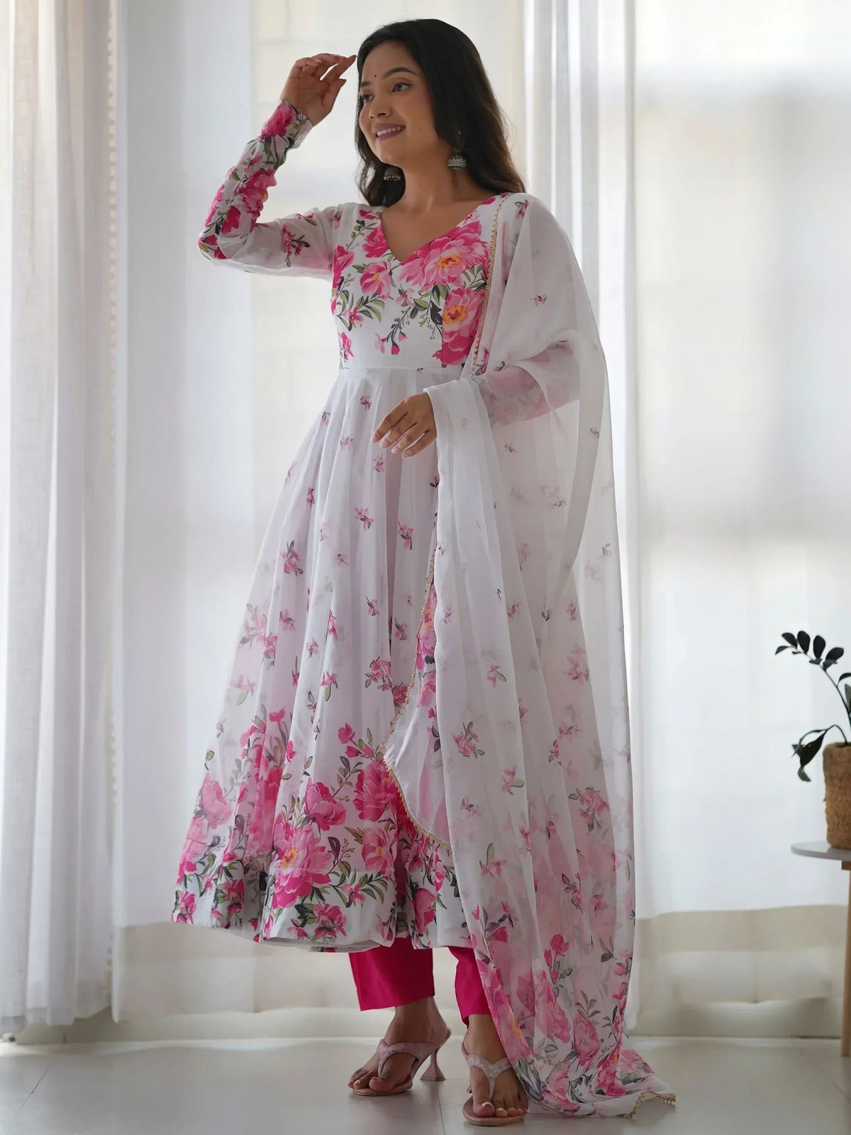 White floral anarkali suit with pink print, paired with matching dupatta and pants, ideal for ethnic occasions.