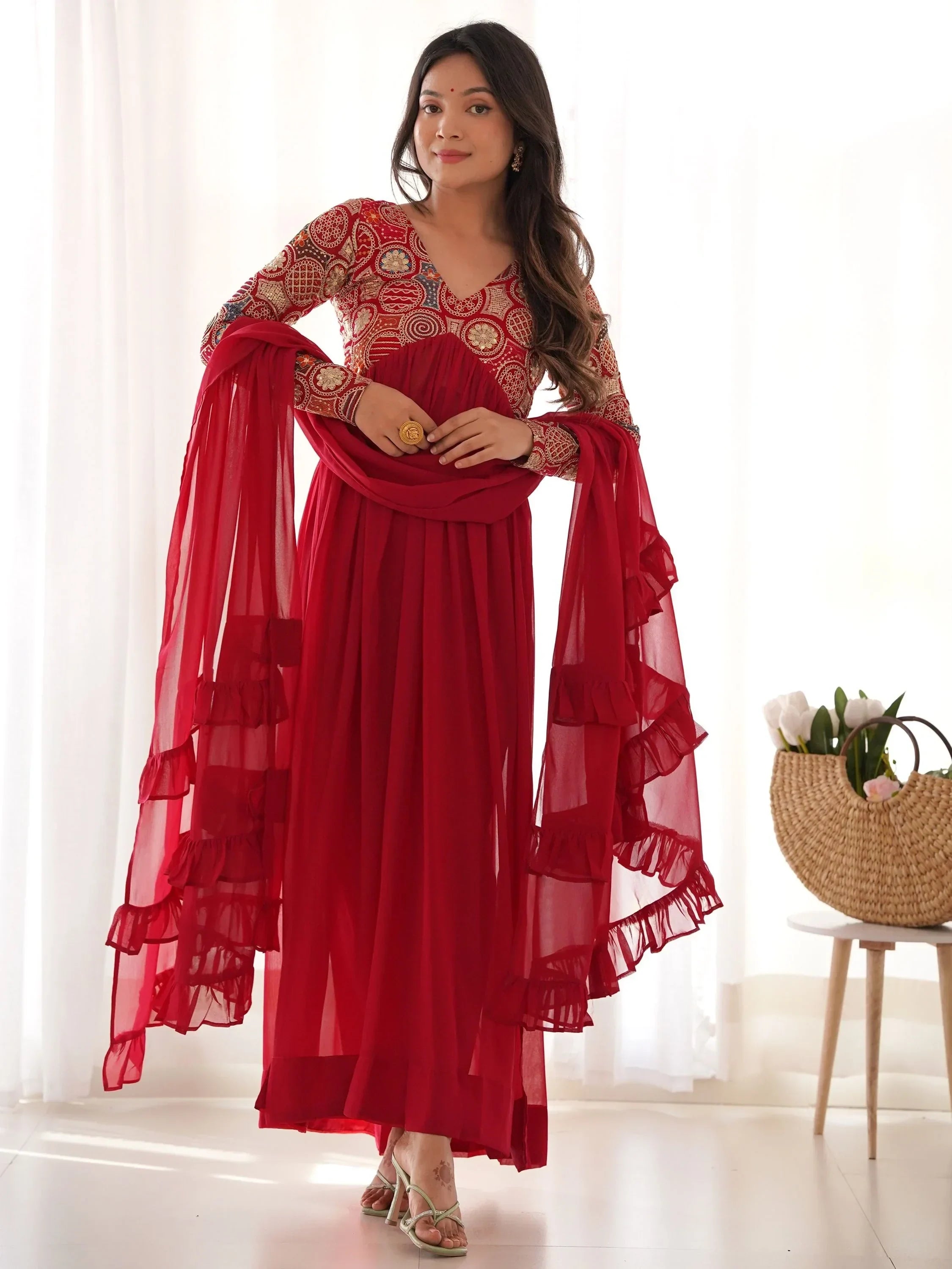 Woman in red embroidered Anarkali gown with ruffle dupatta, traditional Indian wear