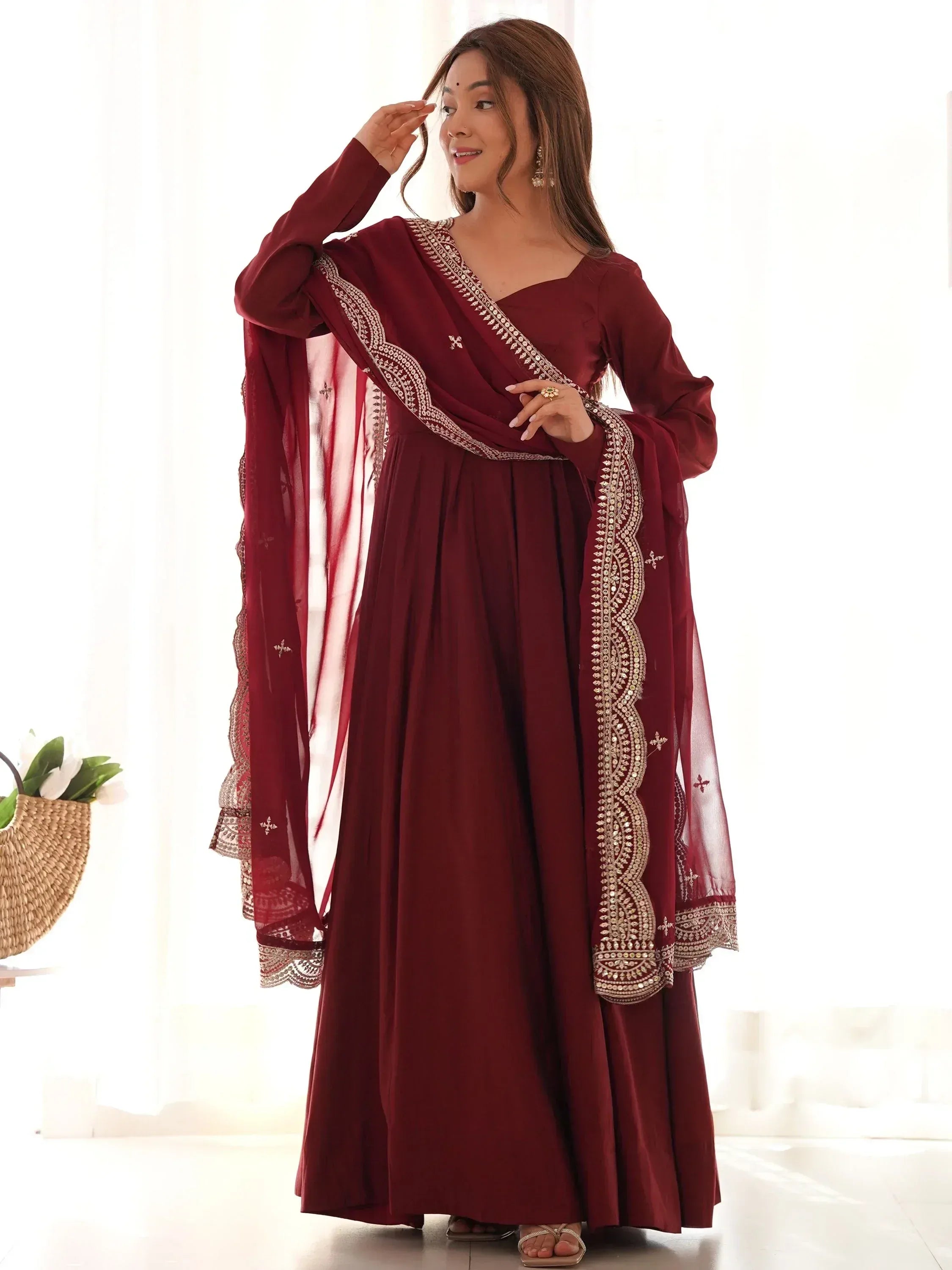 Maroon ethnic gown with gold embroidery and sheer dupatta, perfect for Indian occasions