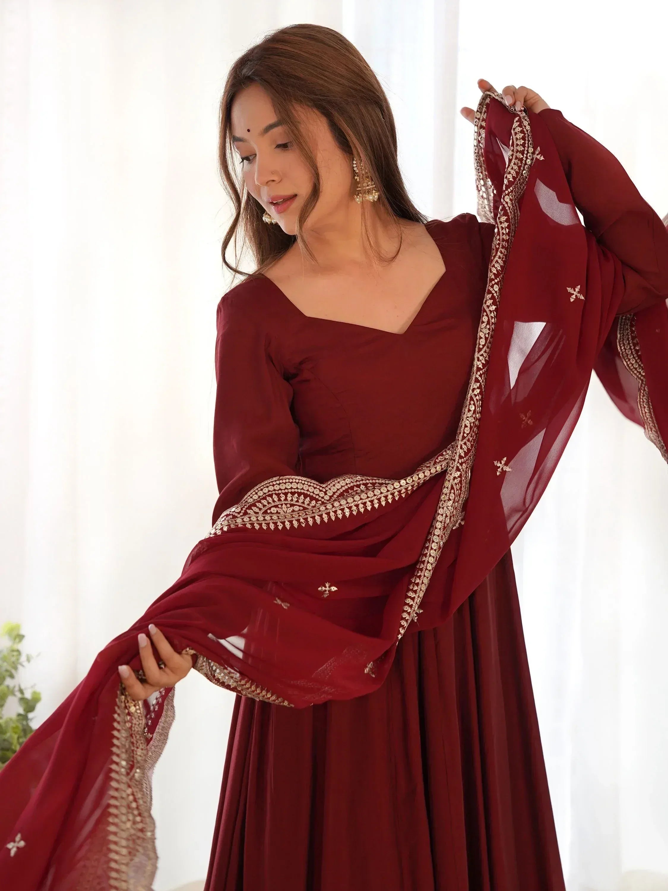Maroon ethnic gown with gold embroidery, perfect for Indian weddings and festive occasions