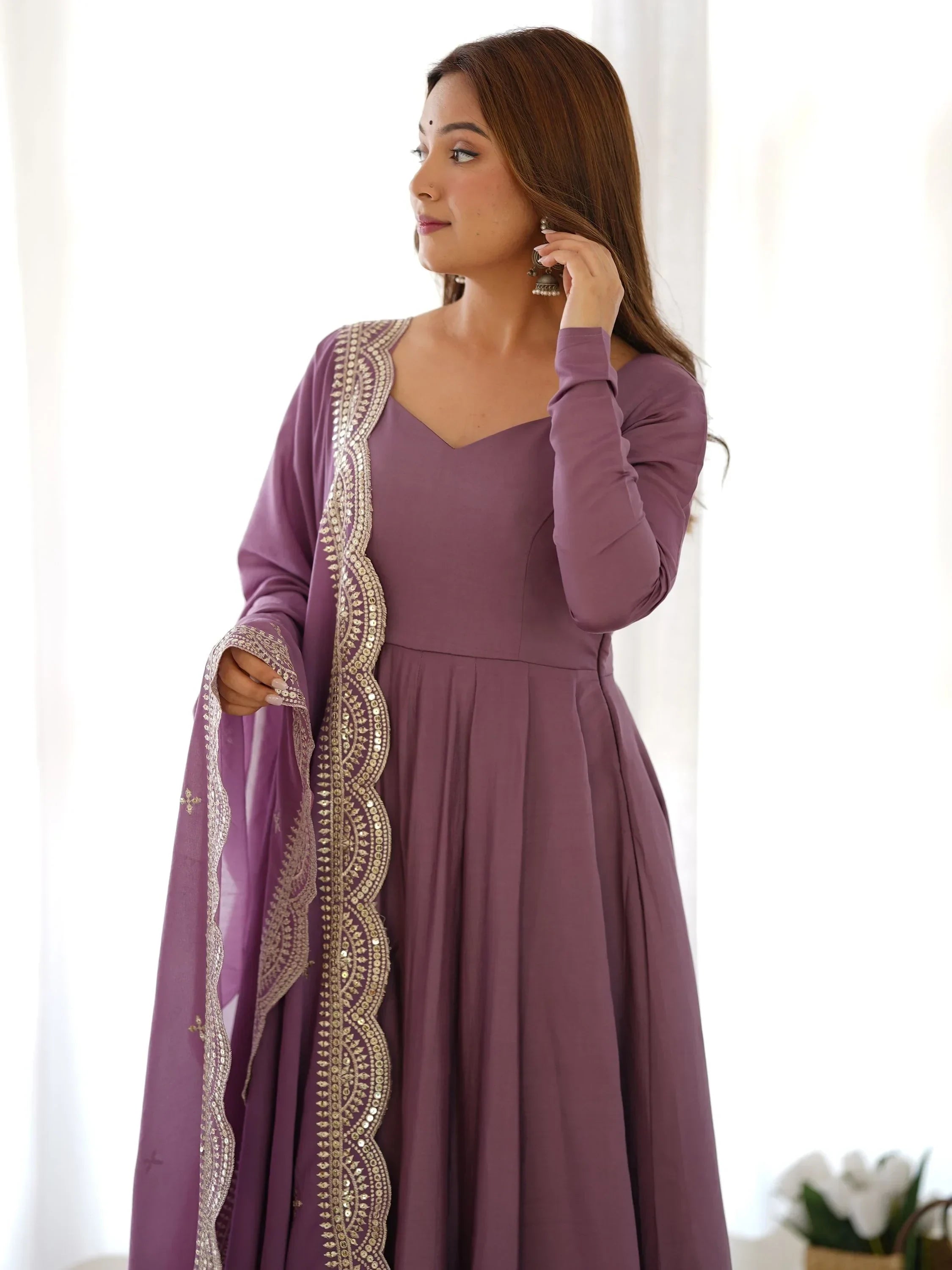 Woman in mauve ethnic gown with dupatta featuring sequin border, traditional Indian wear