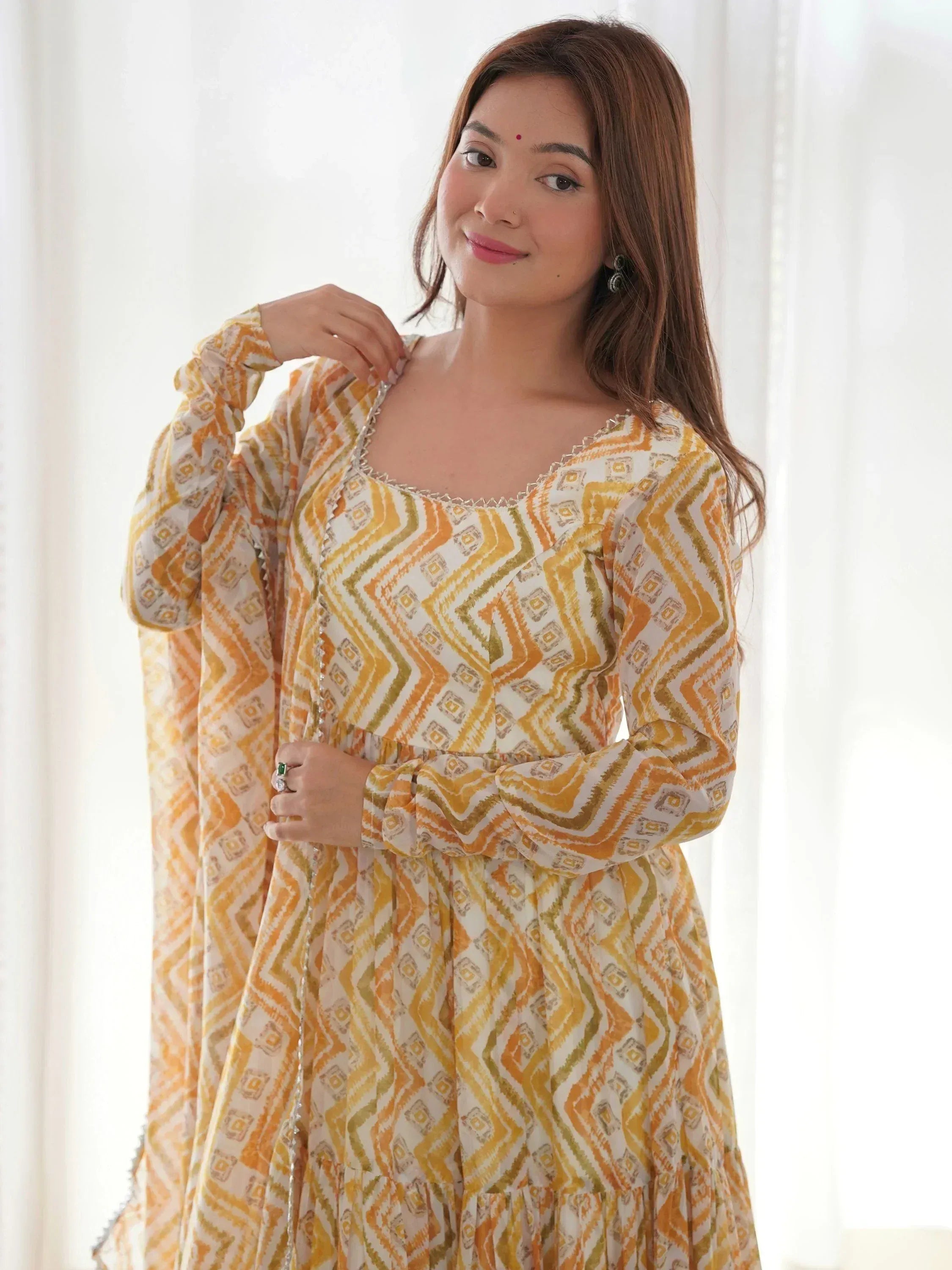 Woman in yellow and white geometric print ethnic gown with long sleeves and square neckline