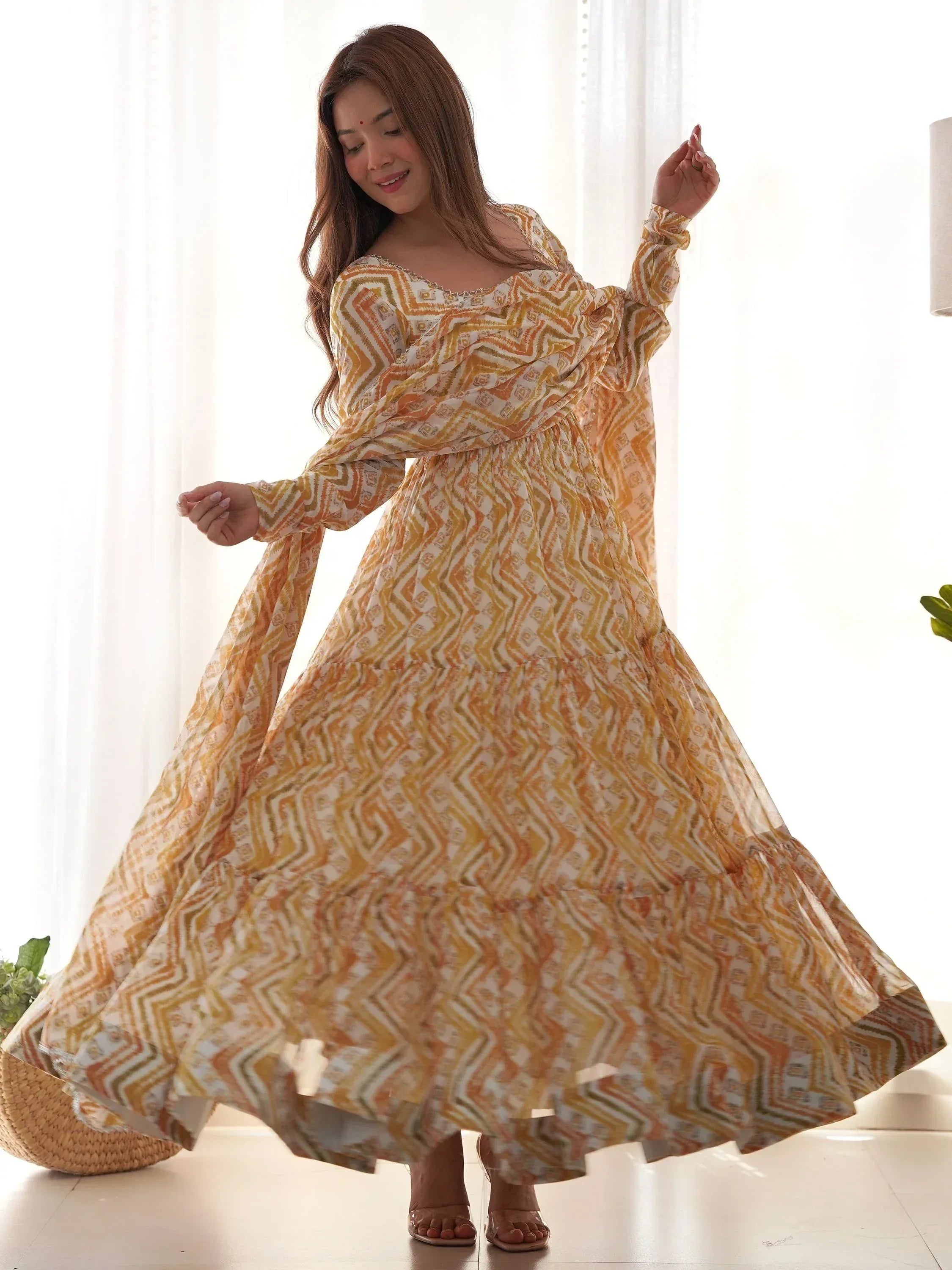 Woman in flowing yellow geometric print ethnic gown with long sleeves, perfect for Indian occasions