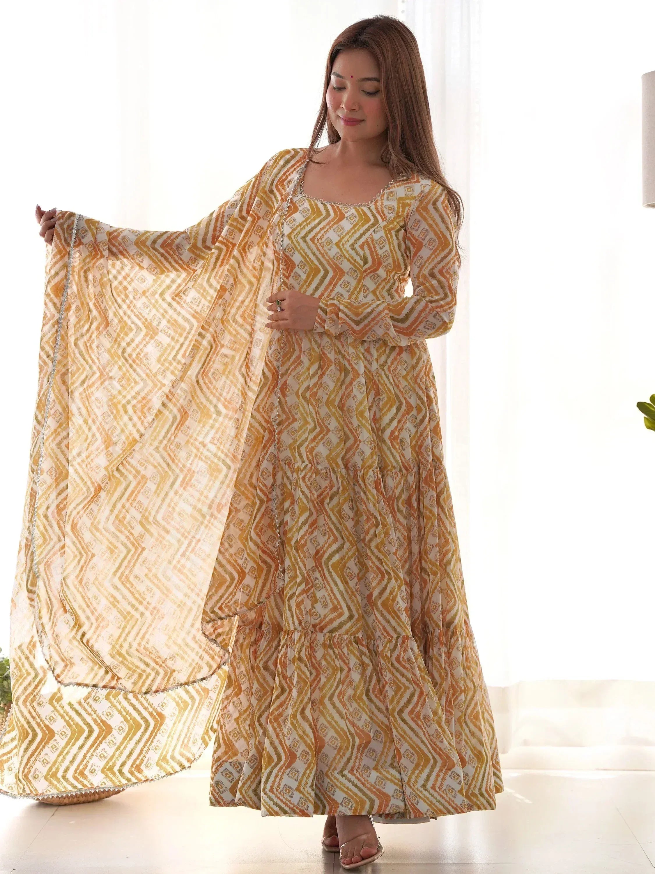 Woman in yellow and white geometric print ethnic gown with matching dupatta, stylish Indian wear
