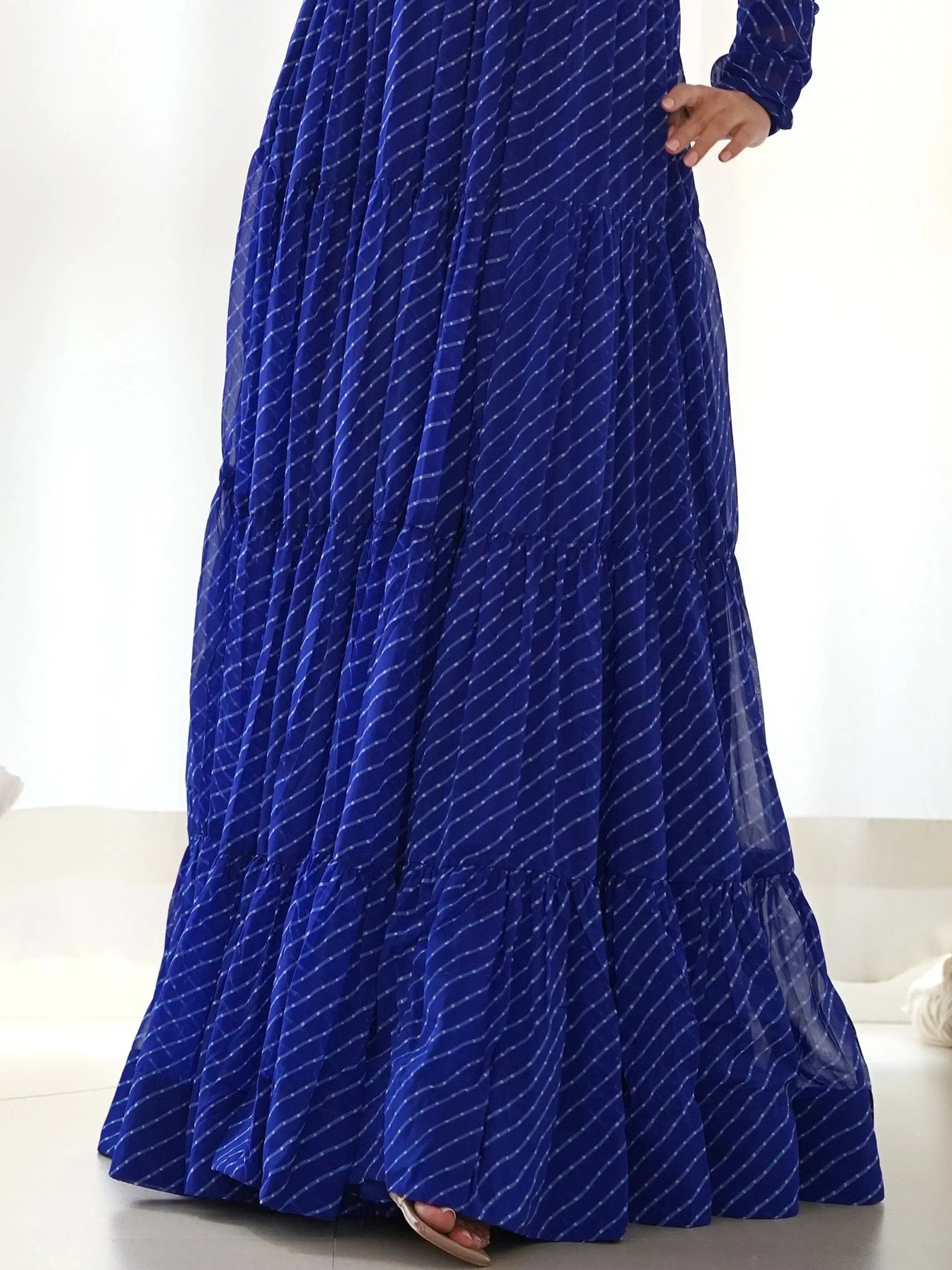Royal blue ethnic gown with white diagonal stripes and tiered ruffle skirt, perfect for festive occasions.