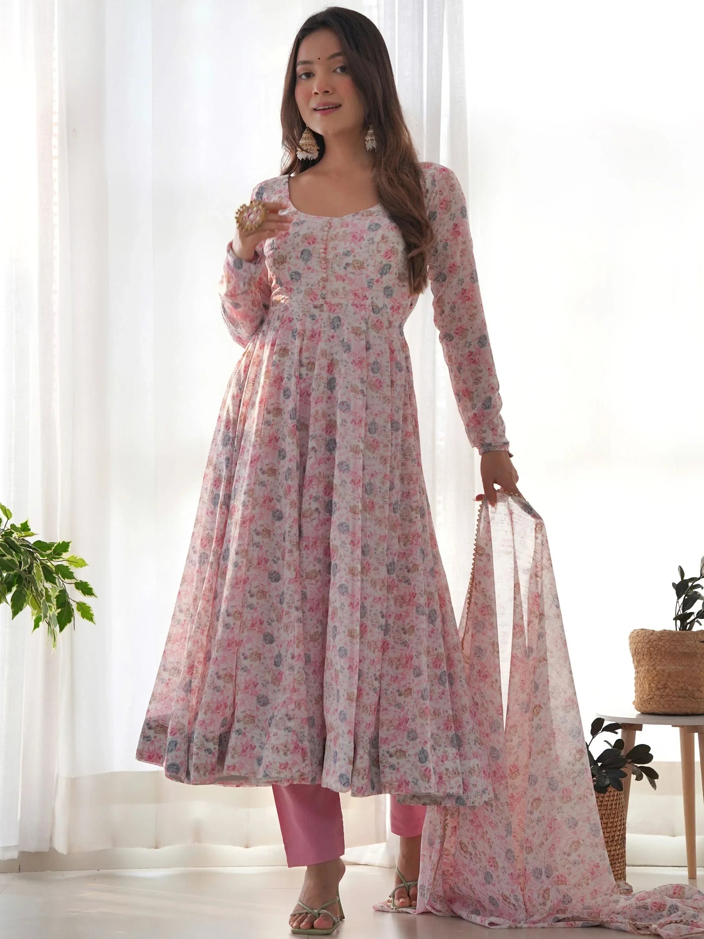 Woman in floral printed Anarkali suit with pink pants and dupatta, ethnic Indian attire