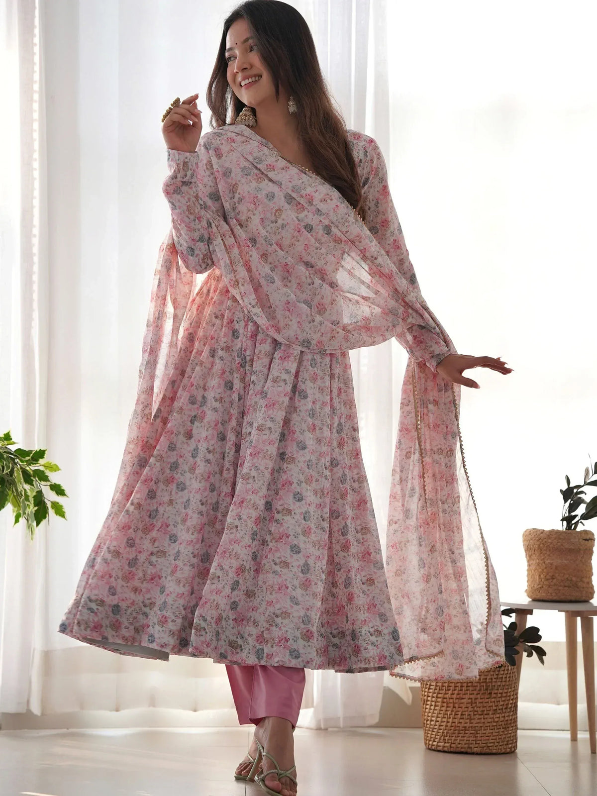Woman in floral print Indian ethnic gown with matching dupatta, styled for festive occasions