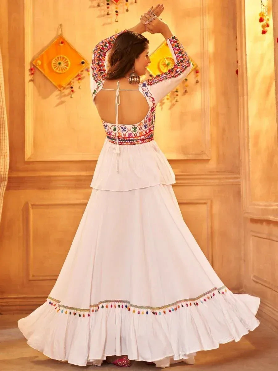 White embroidered ethnic gown with colorful mirror work, back tie detail, and flared skirt for festive occasions