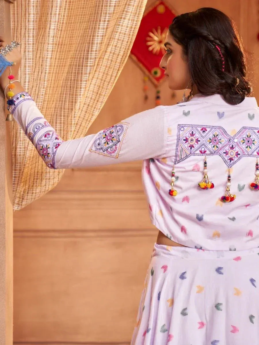 Woman in embroidered lavender ethnic top and skirt, showcasing back design with tassels and mirror work