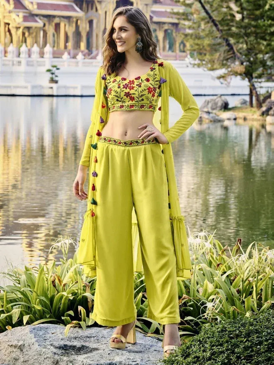 Woman in green embroidered crop top and palazzo pants ethnic outfit by a lake
