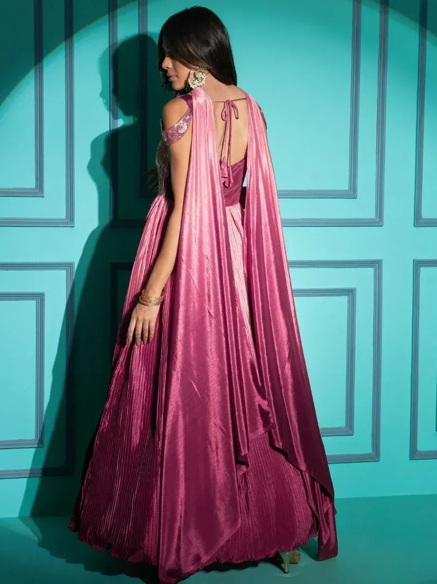 Pink ethnic gown with cape back, pleated skirt, and lace sleeves for Indian occasions