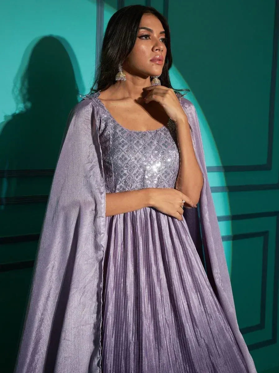 Woman wearing lavender ethnic gown with sequins and attached cape sleeves