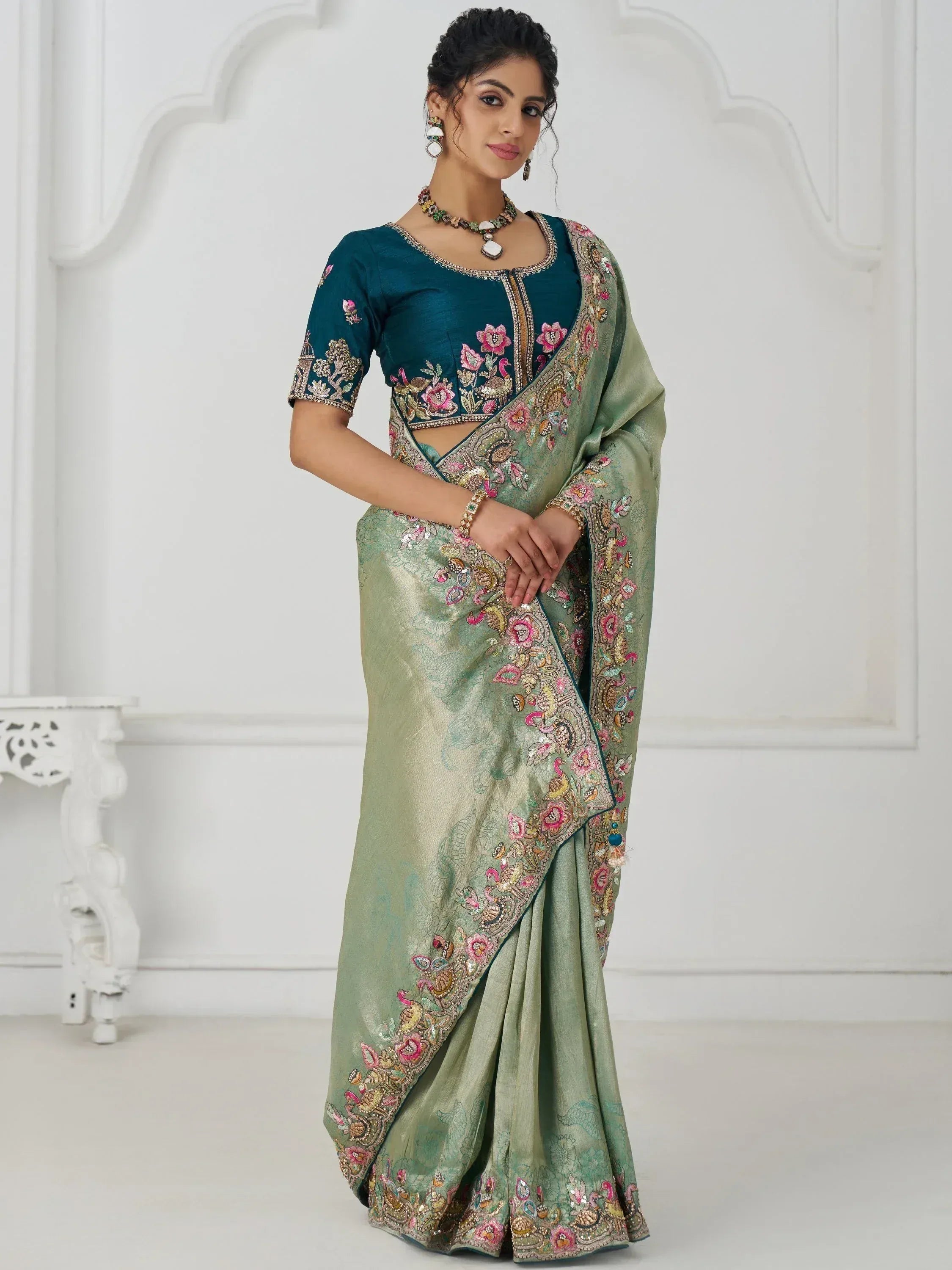 Elegant green saree with floral embroidery and teal blouse, perfect for Indian ethnic occasions