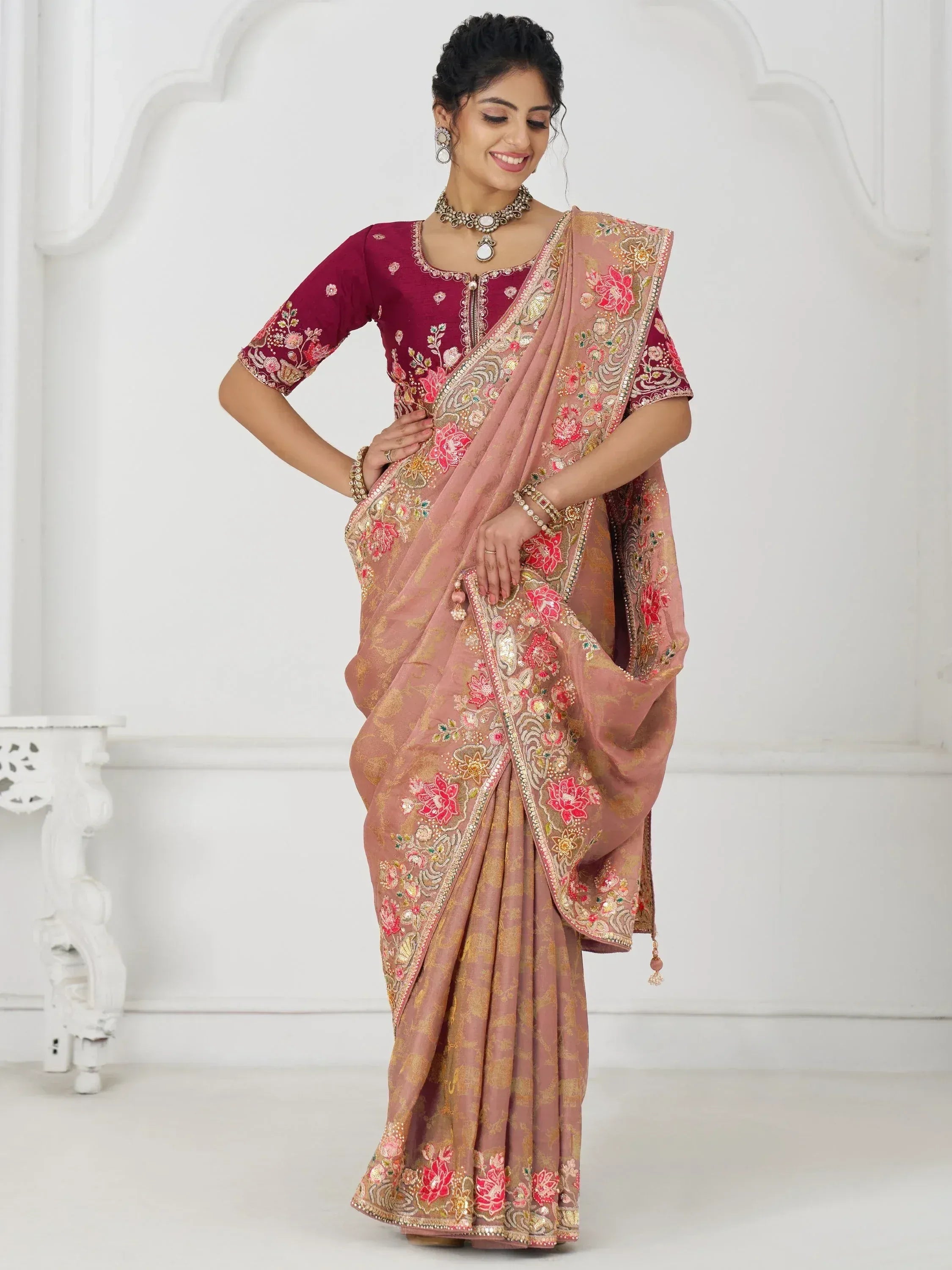 Woman in elegant pink and maroon embroidered saree with floral motifs, perfect for Indian ethnic occasions