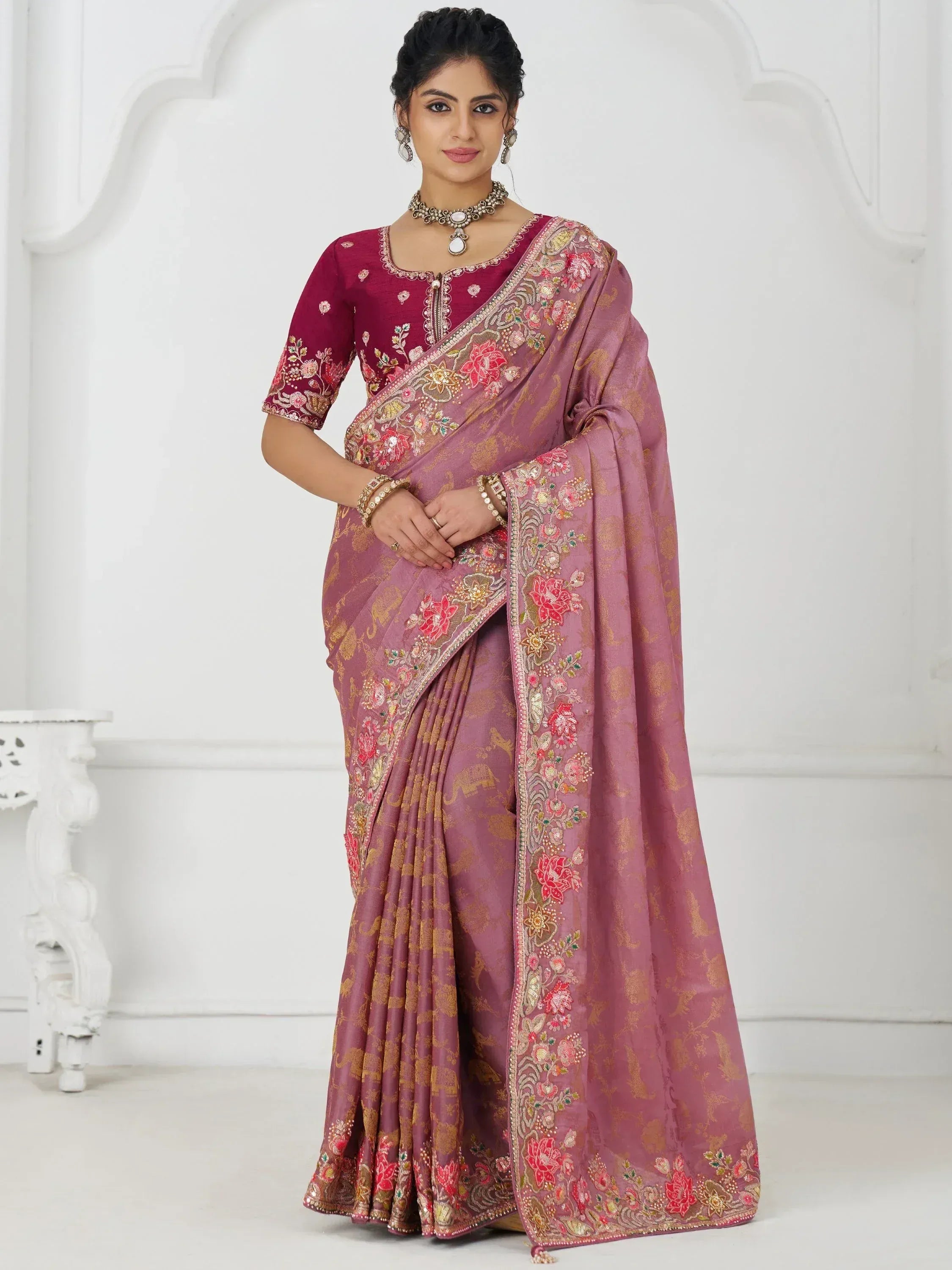 Elegant pink embroidered saree with floral motifs and matching blouse, perfect for Indian ethnic occasions.