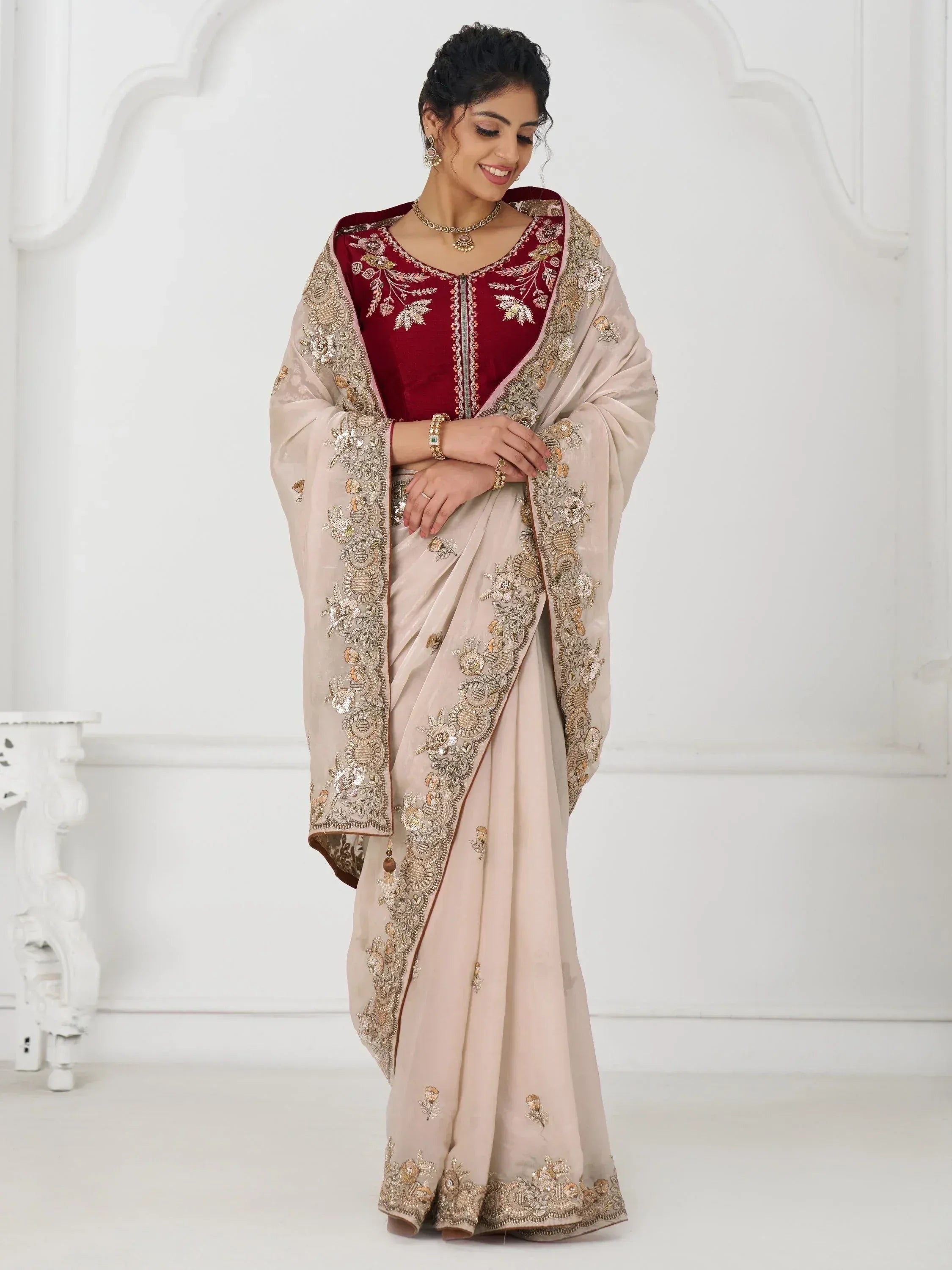 Elegant beige saree with gold embroidery and maroon blouse, perfect for Indian ethnic occasions.