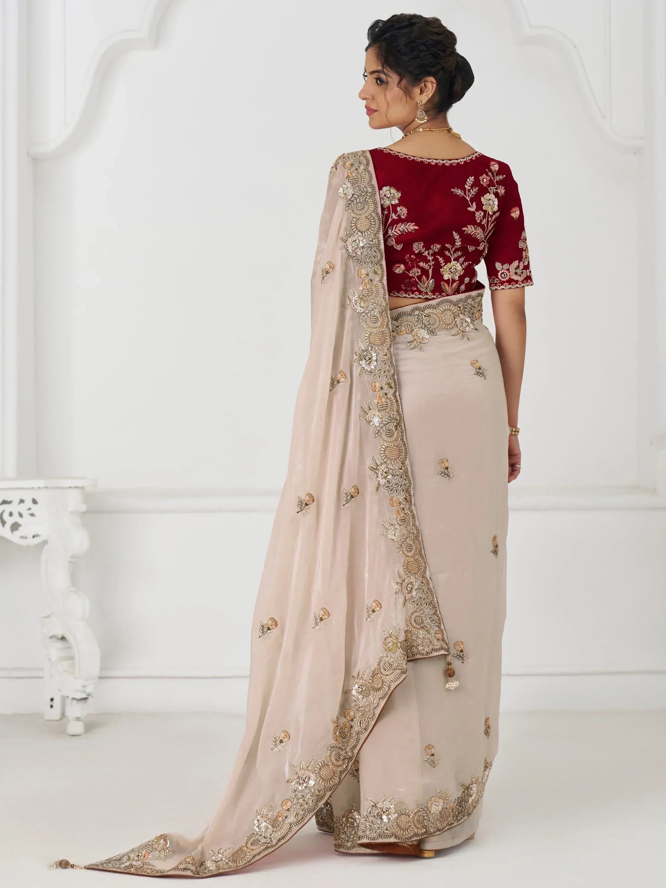 Elegant beige lehenga with gold embroidery, paired with a maroon velvet blouse, perfect for Indian ethnic occasions.