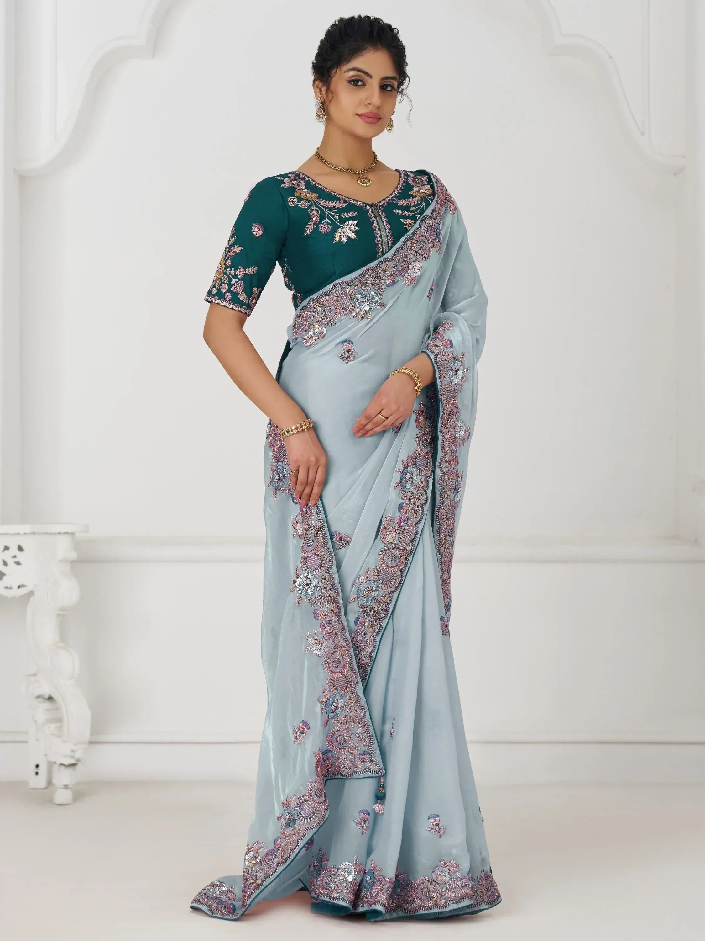 Elegant light blue saree with heavy floral embroidery and teal blouse, perfect for Indian ethnic occasions.