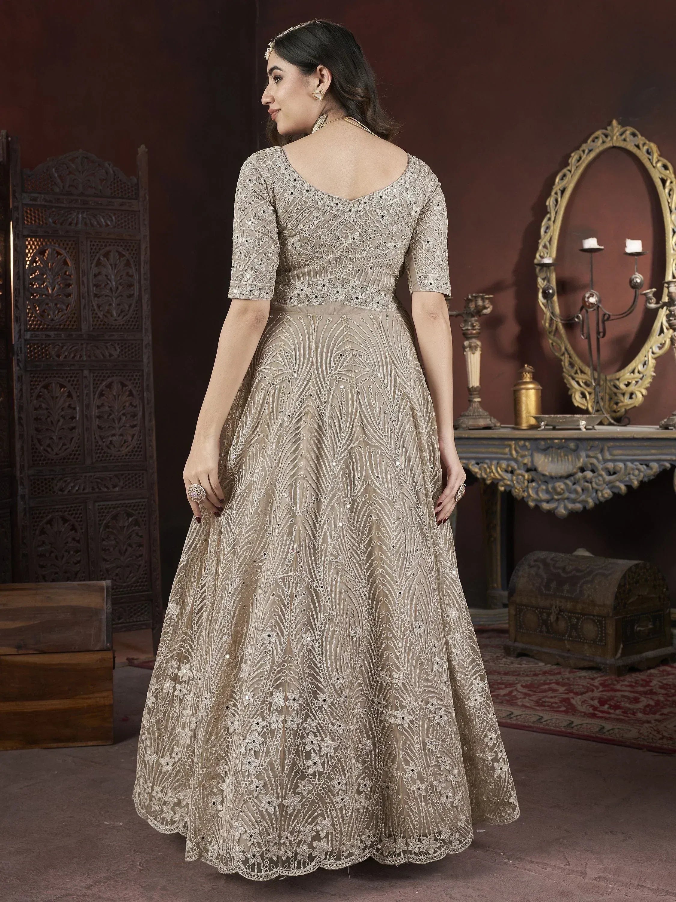 Elegant beige embroidered lehenga choli with intricate floral patterns and a scalloped hem.