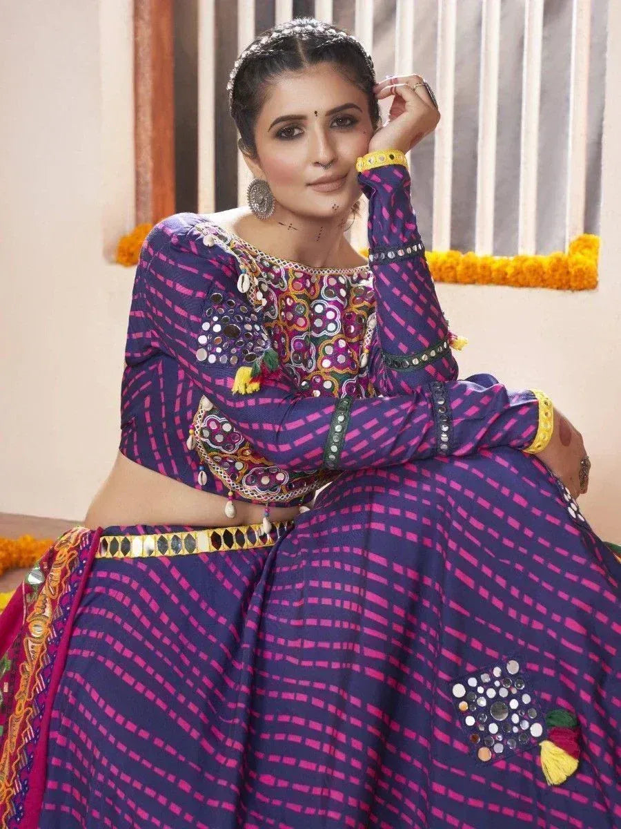 Purple and pink ethnic lehenga choli with mirror work and tassels, perfect for Indian festivals and weddings